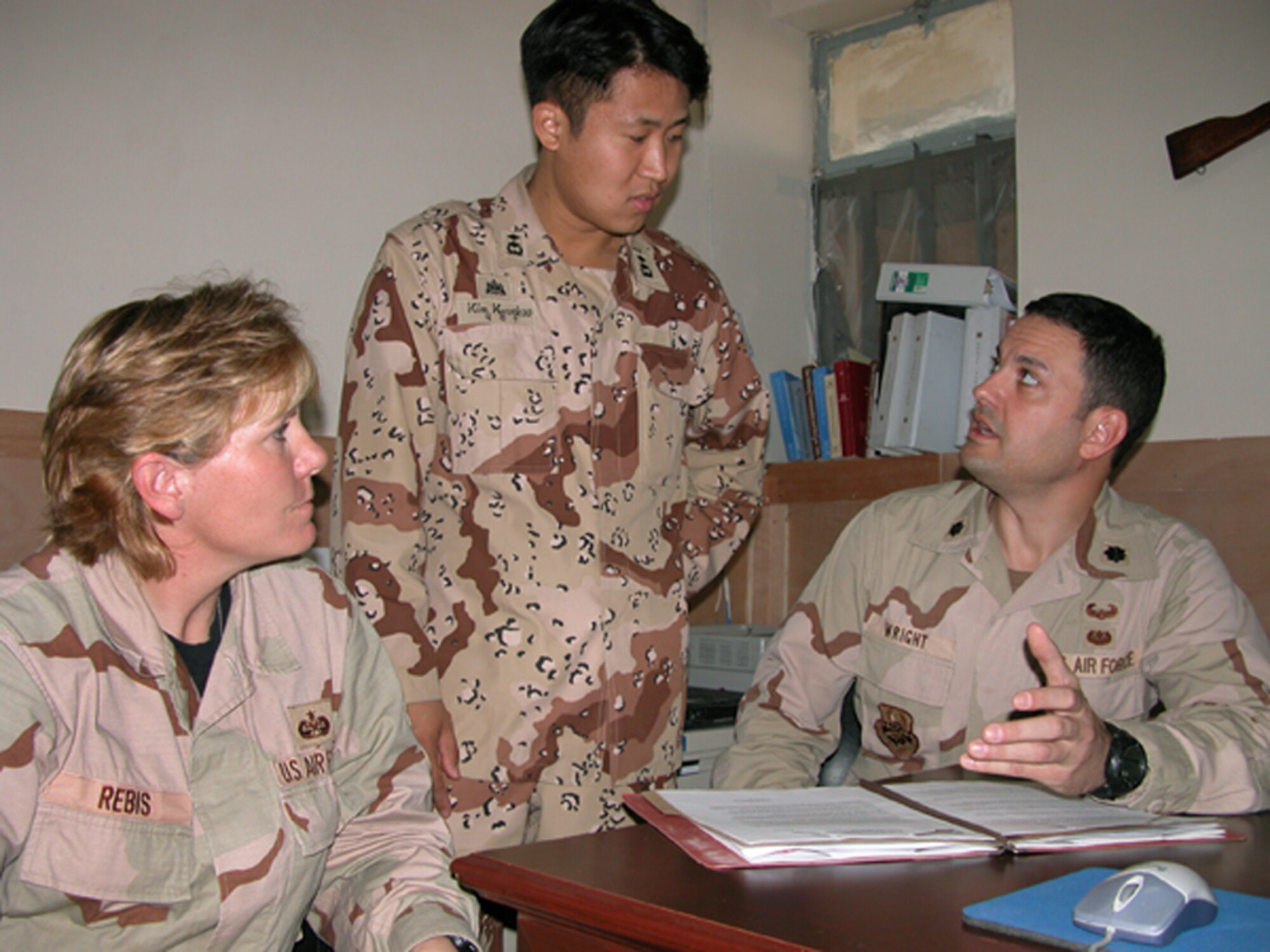 TALLIL AIR BASE, Iraq -- Lt. Col. Brent Wright (right) and Master Sgt. Mary Alice Rebis review a  legal claim with 1st lt. Kim Kwankoo, a Korean military lawyer here.  Colonel Wright and Sergeant Rebis are assigned to the 332nd Air Expeditionary Wing legal office.  (U.S. Air Force photo by Tech. Sgt. Bob Oldham)