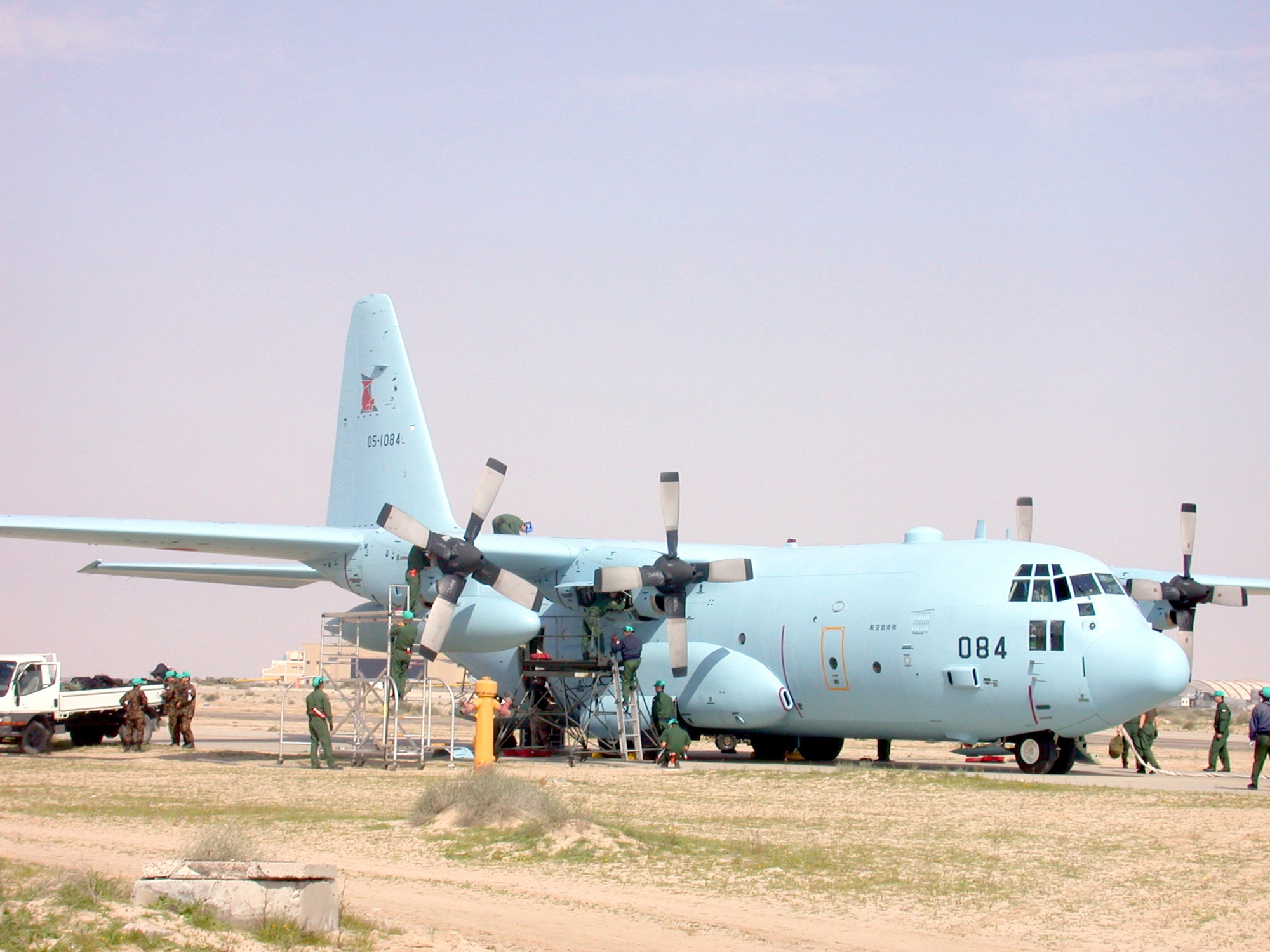The first of three Japanese C-130Hs receives maintenance after landing at a forward-deployed location Jan. 30.  The JASDF will support humanitarian missions as part of the coalition forces.  (U.S. Air Force photo by Senior Airman James C. Dillard)
