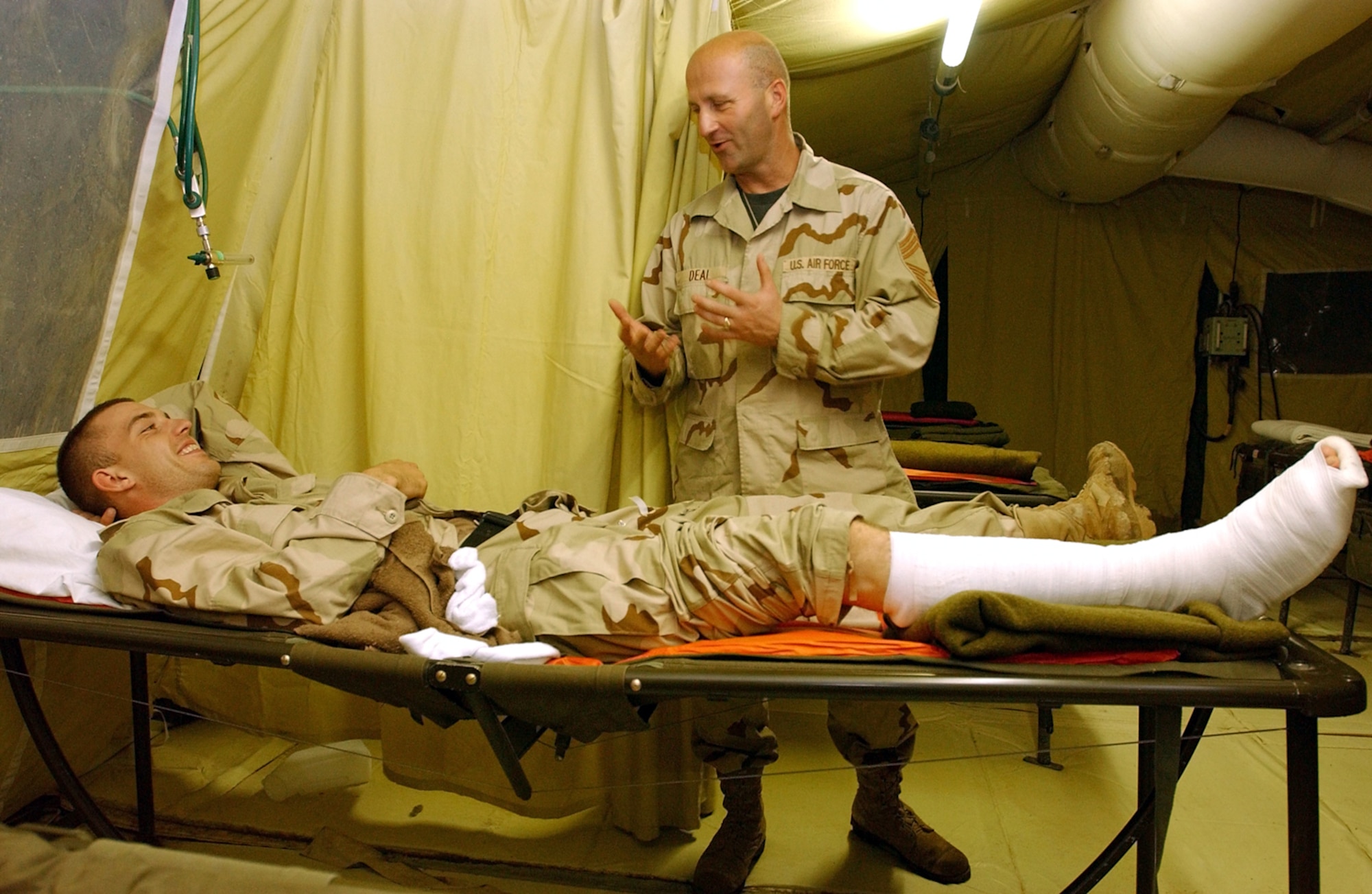 BAGHDAD INTERNATIONAL AIRPORT, Iraq -- Chief Master Sgt. Barry Deal talks with Army Spc. Samuel Tolley at the Contingency Aeromedical Staging Facility here.  Specialist Tolley suffered a staff infection in his foot.  Volunteers help the CASF staff and comfort patients.  Chief Deal is assigned to the 447th Expeditionary Communications Squadron and Specialist Tolley is assigned to the 394th Quartermaster Battalian.  (U.S. Air Force photo by Tech. Sgt. Lisa Zunzanyika)