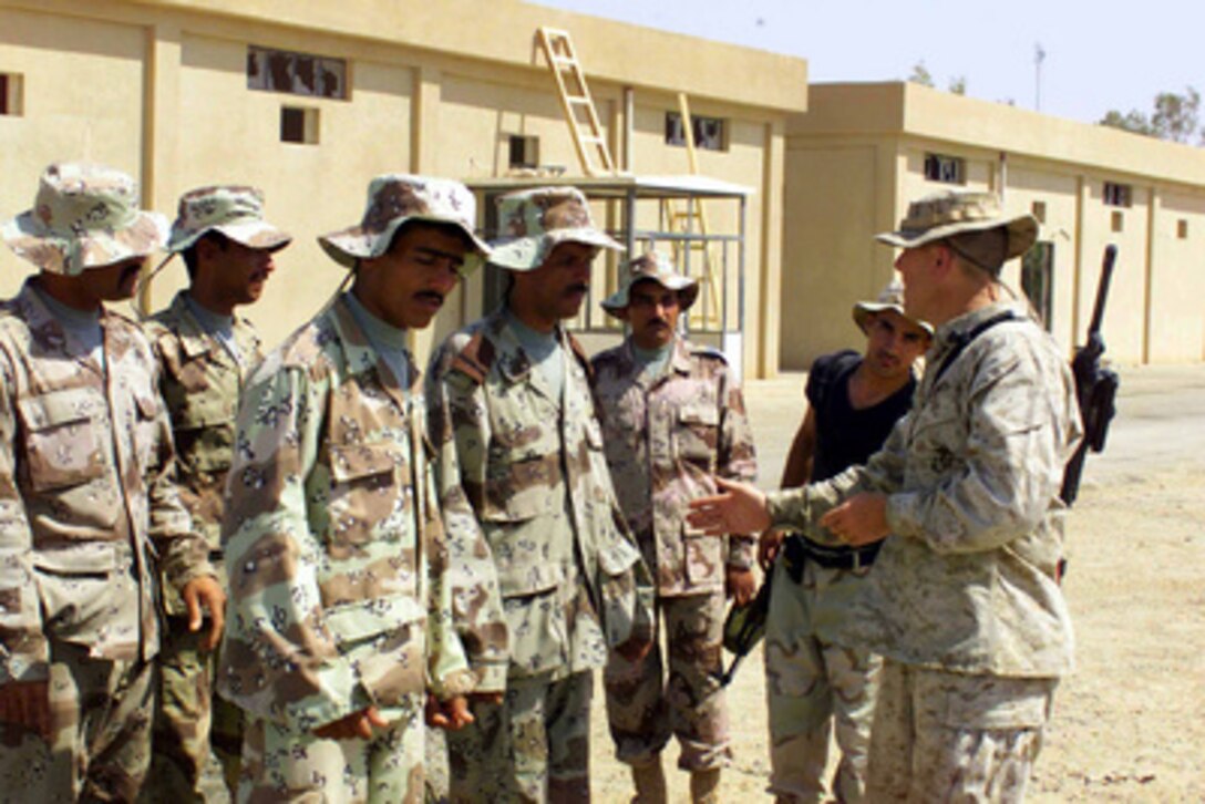 Marine Sgt. Eric S. Widerman (right) instructs Iraqi Civil Defense Corps recruits at India Base in Nasir Waal Salaam, Iraq, on June 7, 2004. Widerman is attached to Golf Company, 2nd Battalion 1st Marine Regimental Combat Team, 1st Marine Division which is currently engaged in security and stabilization operations in Iraq. 
