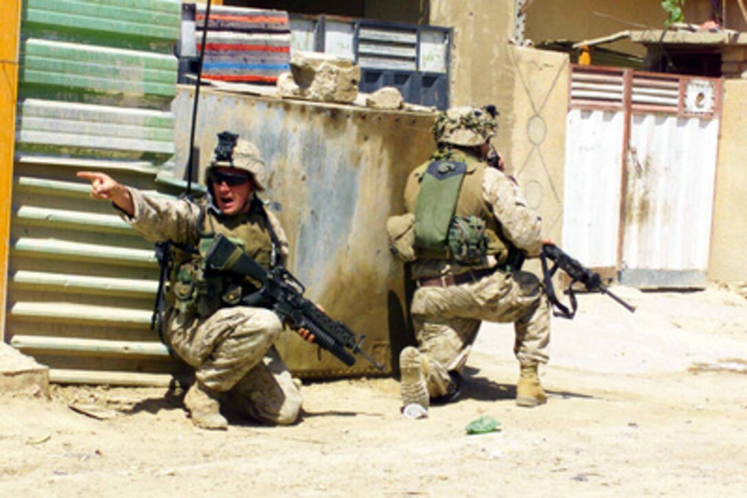 A Marine of the 1st Marine Division shouts instructions to soldiers of the Iraqi Civil Defense Corps during a firefight while on a joint patrol in Nasir Waal Salaam, Iraq, on June 5, 2004. The 1st Marine Division is deployed in support of Operation Iraqi Freedom and is engaged in Security and Stabilization Operations in the Al Anbar province of Iraq. 