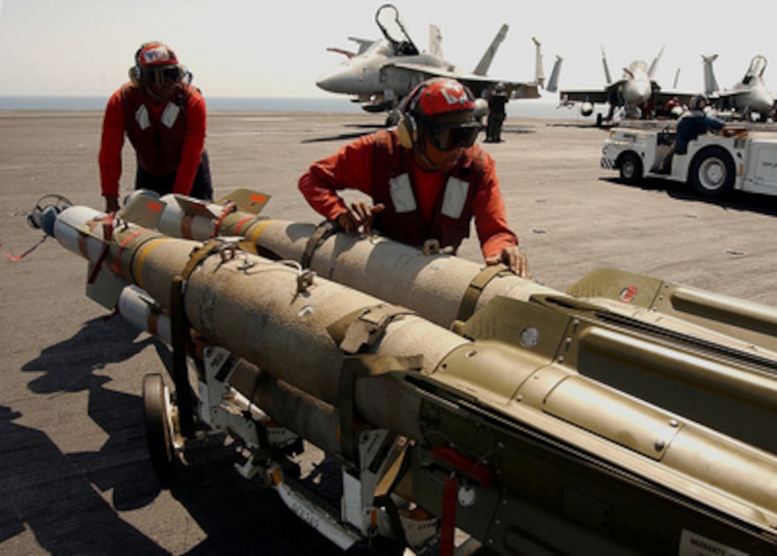 Navy Petty Officer 3rd Class Quadar Edwards (left) and Airman Jaris Palmer transport GBU-12 Guided Bomb Units across the flight deck of the USS George Washington (CVN 73) on June 28, 2004. Edwards, from Rahway, N.J., and Palmer, from York, Penn., serve as aviation ordnancemen. The Norfolk, Va., based nuclear powered aircraft carrier is deployed in support of Operation Iraqi Freedom. 