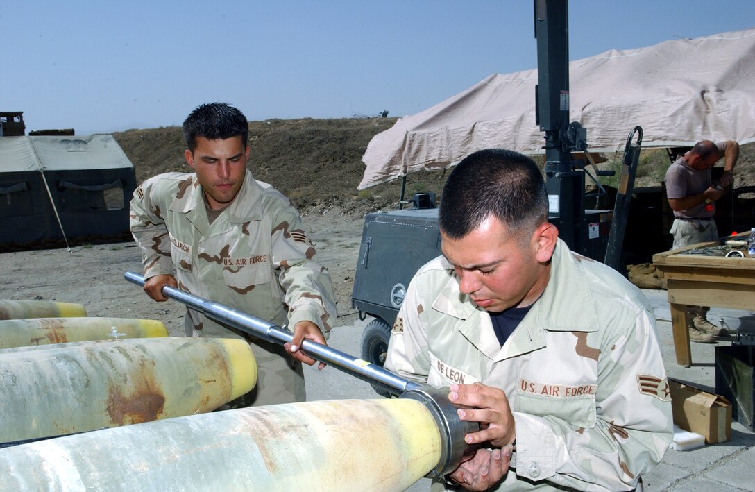 BAGRAM AIR BASE, Afghanistan -- Senior Airmen Kenneth Kauzlaurich (left) and Luis Deleon torque down the guidance system mounting assembly on the front of a 500-pound laser guided bomb.  The 6-foot wrench allows the pair to put 600 pounds of torque on the assembly.  The Airmen are assigned to the 455th Expeditionary Aircraft Maintenance Squadron and are deployed from Eielson Air Force Base, Alaska.  (U.S. Air Force photo by Master Sgt. Andrew Gates)