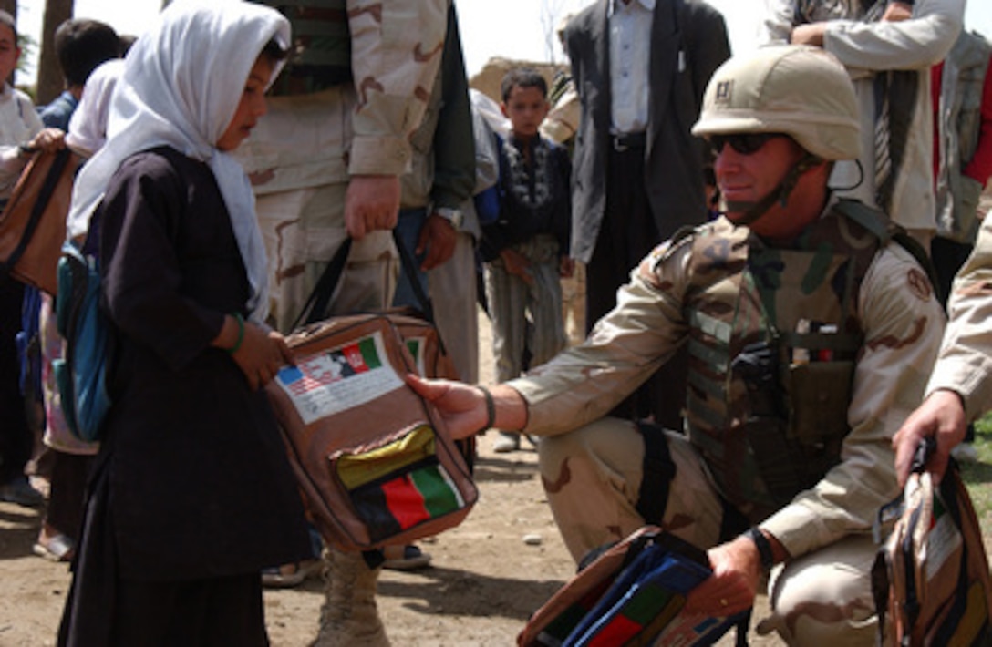 Army Capt. Greg Hanley distributes school supplies to the Smail Kail Secondary School in the Parwan Province of Afghanistan, on July 1, 2004. The supplies were provided by the 325th Field Hospital's Family Support and Kansas City community organizations. Hanley is attached to the 325th Field Hospital. 