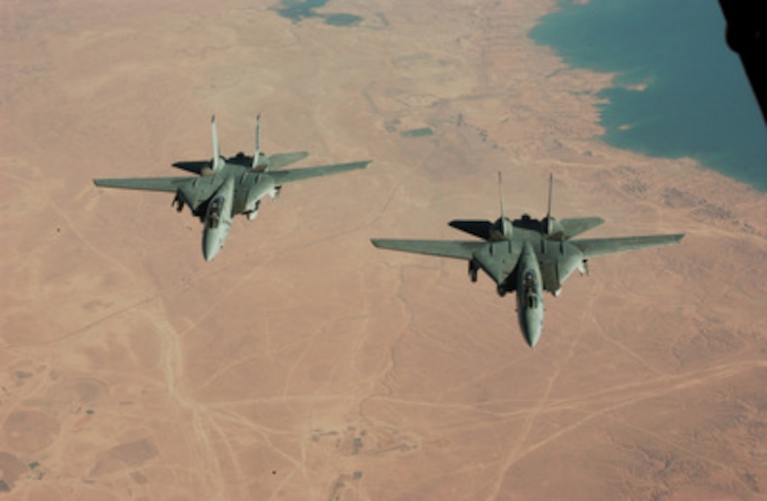 A pair of U.S. Navy F-14B Tomcats soar over the Iraqi landscape after refueling from an Air Force KC-10 from the 908 Expeditionary Air Refueling Squadron on July 4, 2004. 