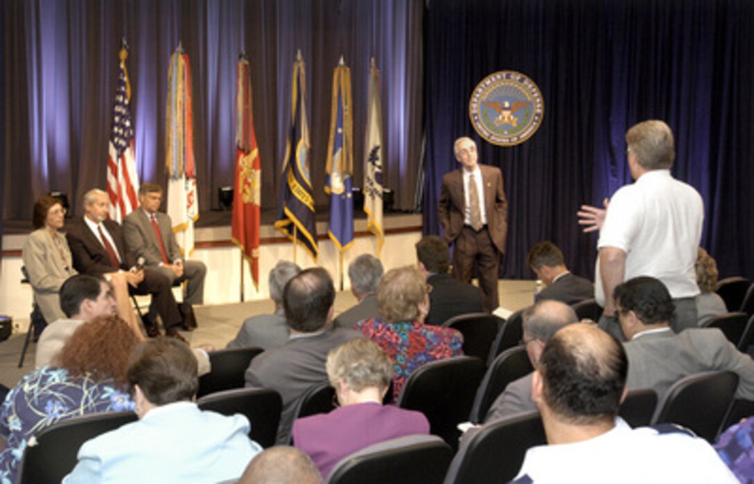 Secretary of the Navy Gordon England (left) listens to a question from a member of the audience during a Pentagon town hall meeting on the development of the new National Security Personnel System held on July 7, 2004. England has been tasked by Secretary of Defense Donald H. Rumsfeld with overseeing the development of the new system and was joined on stage by three senior managers from the project (left to right), Program Executive Officer Mary Lacey, Ronald Sanders of the Office of Personnel Management, and Principal Deputy Under Secretary of Defense for Personnel and Readiness Charles S. Abell. 