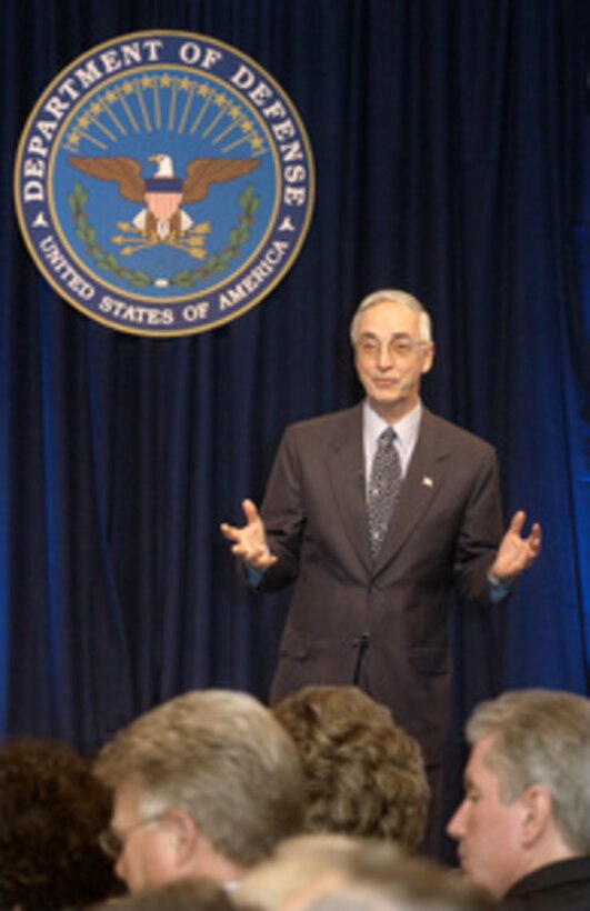 Secretary of the Navy Gordon England speaks to the audience at a Pentagon town hall meeting on July 7, 2004. England addressed the audience of military and civilians on the new National Security Personnel System. England has been tasked by Secretary of Defense Donald H. Rumsfeld with overseeing the development of the new system and was joined on stage by three senior managers from the project (left to right), Program Executive Officer Mary Lacey, Ronald Sanders of the Office of Personnel Management, and Principal Deputy Under Secretary of Defense for Personnel and Readiness Charles S. Abell. 