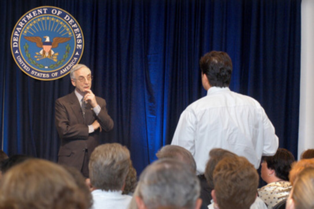 Secretary of the Navy Gordon England (left) listens to a question from a member of the audience during a Pentagon town hall meeting on the development of the new National Security Personnel System held on July 7, 2004. England has been tasked by Secretary of Defense Donald H. Rumsfeld with overseeing the development of the new system and was joined on stage by three senior managers from the project, Program Executive Officer Mary Lacey, Ronald Sanders of the Office of Personnel Management, and Principal Deputy Under Secretary of Defense for Personnel and Readiness Charles S. Abell. 