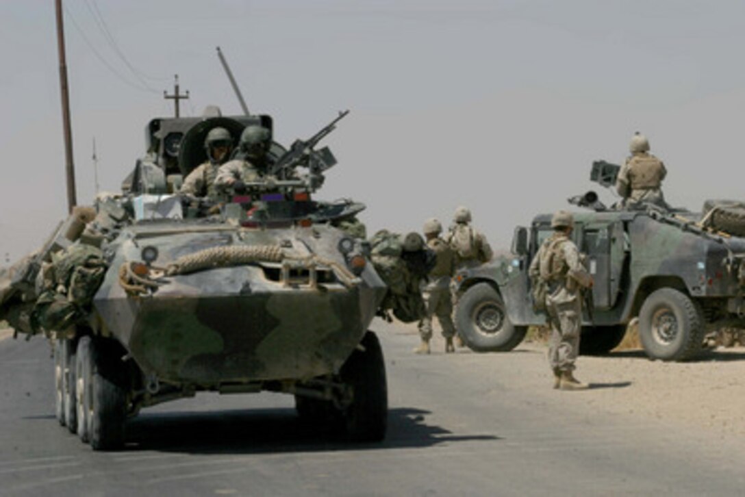 Marine Light Armored Vehicles come through a check point set up by Marines of 2nd Platoon, Kilo Company, 3rd Battalion 7th Marines, 1st Marine Division, while they patrol the streets of Karabilah, Iraq, on June 14, 2004. The 1st Marine Division is deployed in support of Operation Iraqi Freedom and engaged in Security and Stabilization Operations in the Al Anbar province in Iraq. 