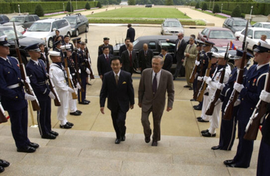 Secretary of Defense Donald H. Rumsfeld (right) escorts the President of Mongolia Natsagiyn Bagabandi through an honor cordon and into the Pentagon on July 15, 2004. The two leaders will meet to discuss defense issues of mutual interest. 