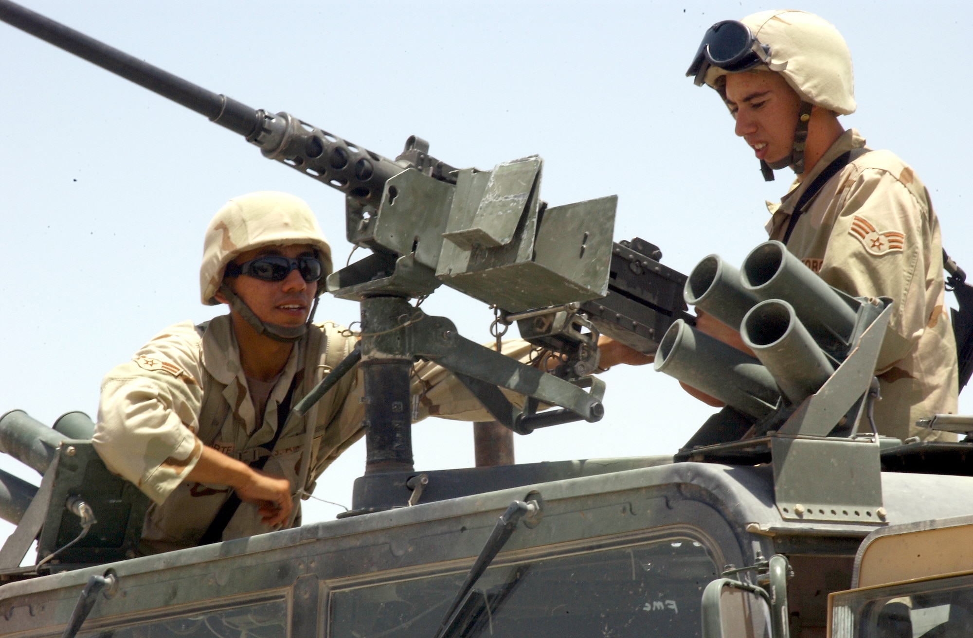 SOUTHWEST ASIA -- Airman 1st Class Gurtavo Corte (left) and Senior Airman Douglas Thompson inspect their .50-caliber machine gun mounted on a Humvee during a live-fire training exercise July 13.  More than 150 Airmen completed the final stages of live-fire convoy training at Balad Air Base, Iraq, on July 16 before deploying north to Mosul as part of the 494th Air Expeditionary Force Truck Company. (U.S. Air Force photo by Airman 1st Class Heather Norris)