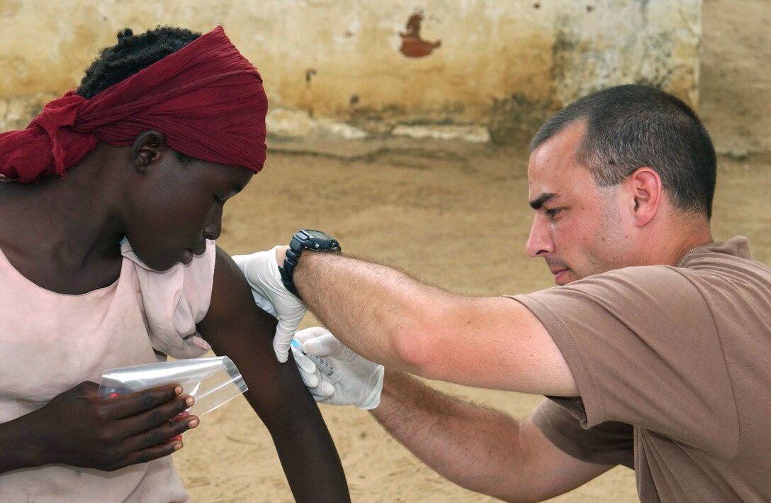 CAMP LOUMIA, Chad -- Staff Sgt. Rick English immunizes a Chadian girl while on a humanitarian mission here.  He is a medical technician with the 439th Aerospace Medical Squadron at Westover Air Reserve Base, Mass.  The medical team saw more than 2,800 patients from 16 villages during the 15-day mission.  (U.S. Air Force photo by Tech. Sgt. Chance Babin)