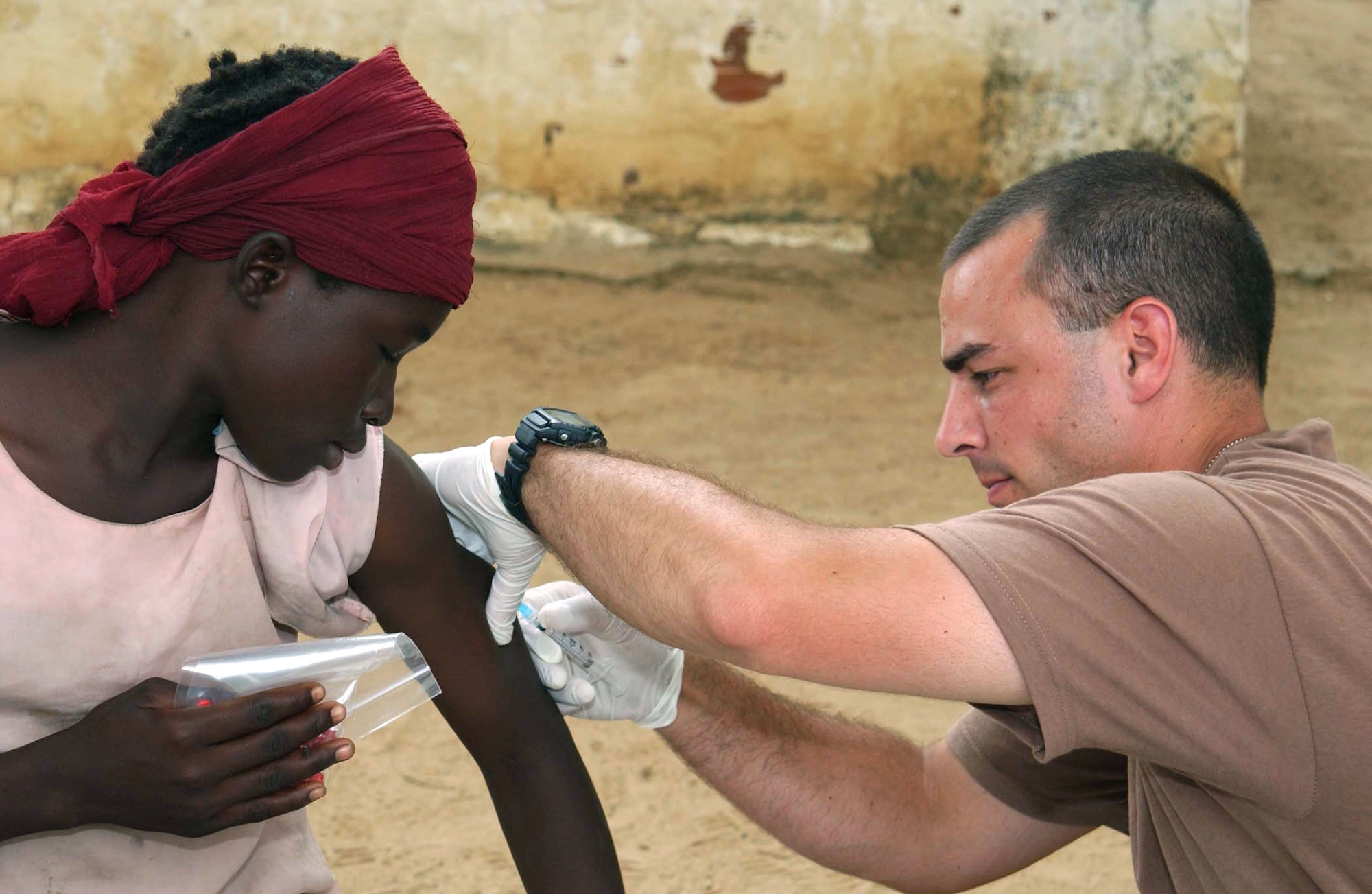 CAMP LOUMIA, Chad -- Staff Sgt. Rick English immunizes a Chadian girl while on a humanitarian mission here.  He is a medical technician with the 439th Aerospace Medical Squadron at Westover Air Reserve Base, Mass.  The medical team saw more than 2,800 patients from 16 villages during the 15-day mission.  (U.S. Air Force photo by Tech. Sgt. Chance Babin)