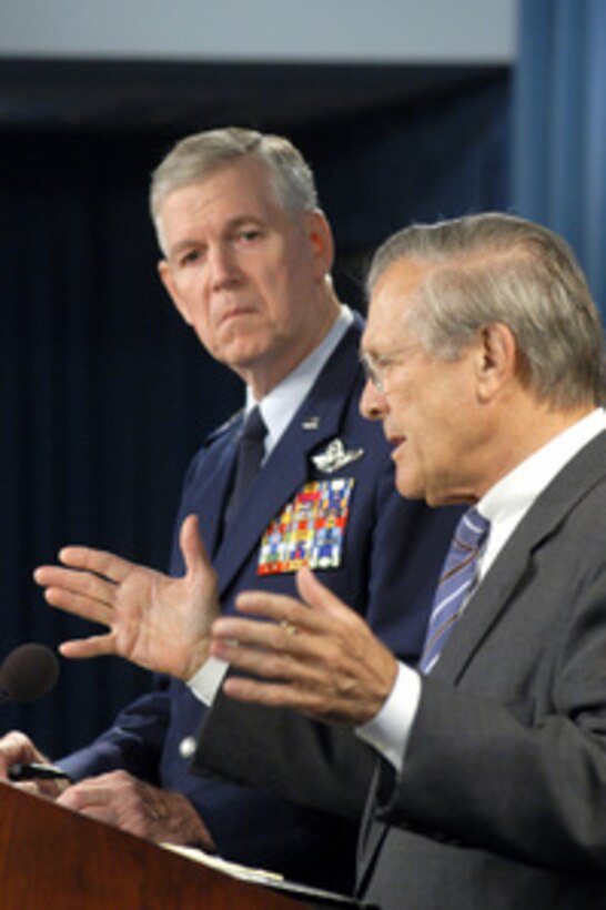 Secretary of Defense Donald H. Rumsfeld responds to a reporter's question during a July 21, 2004, Pentagon press briefing as Chairman of the Joint Chiefs of Staff Gen. Richard B. Myers, U.S. Air Force, looks on. 