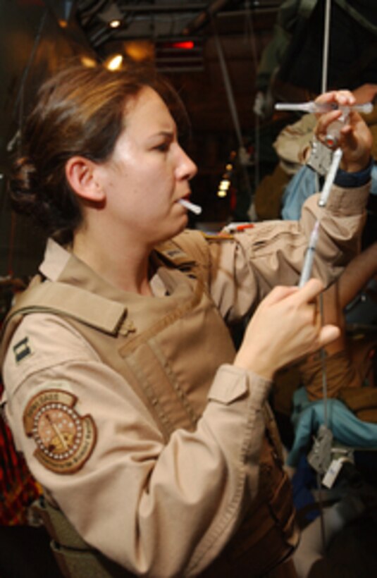 Air Force Capt. Kimberly Brady injects medicine into a patient's intravenous tube during a C-141 Starlifter medevac flight from Balad Air Base, Iraq, to Ramstein Air Base, Germany, on July 8, 2004. Brady is an aeromedical flight nurse with the 791st Expeditionary Aeromedical Evacuation Squadron. The squadron provides a broad scope of in-flight inter-theater aeromedical care by highly trained aeromedical evacuation crews and critical care air transport teams. 
