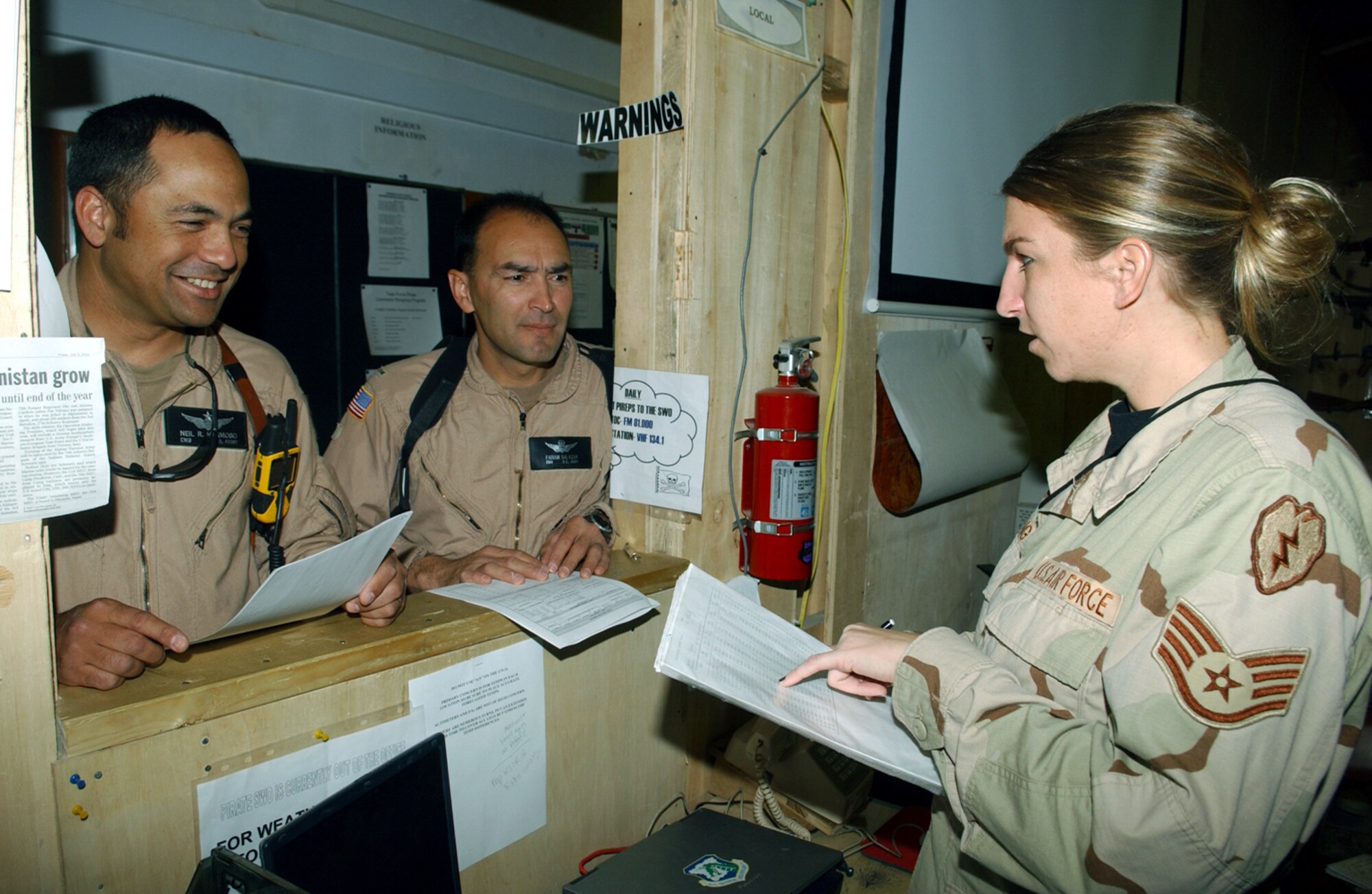 BAGRAM AIR BASE, Afghanistan -- Staff Sgt. Alison Long (right) briefs Army Chief Warrant Officer Neil Hermoso (left), a CH-47 Chinook pilot, and Chief Warrant Officer Fabian Salazar, an AH-64 Apache pilot, on weather conditions before a mission.  Sergeant Long is a weather forecaster for the 25th Infantry Division (Light). (U.S. Air Force photo by Master Sgt. Andrew Gates)