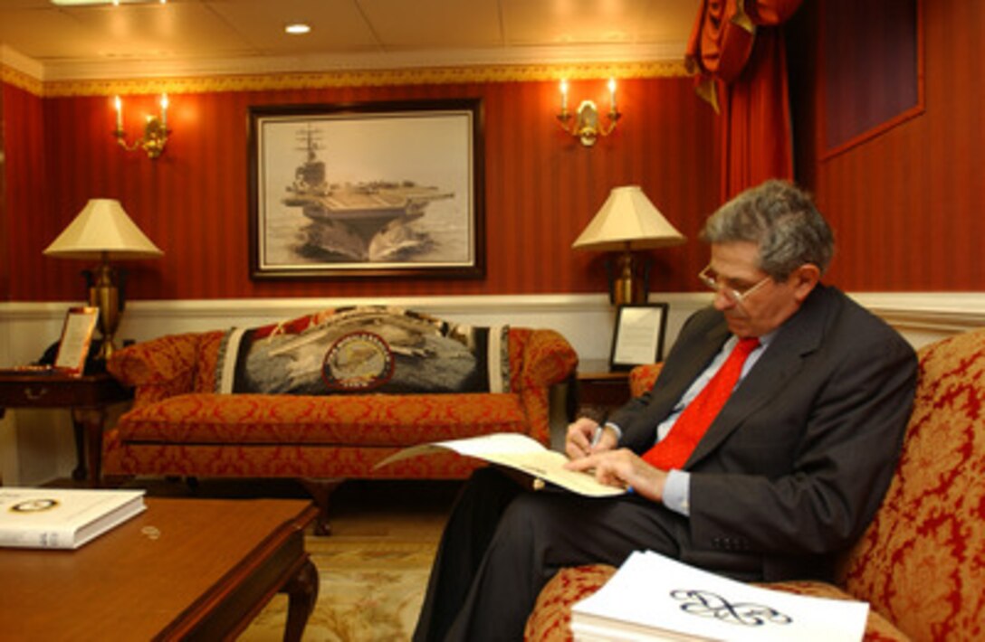 Deputy Secretary of Defense Paul Wolfowitz signs a Certificate of Reenlistment in the captain's cabin of the USS Ronald Reagan (CVN76) on July 23, 2004. Wolfowitz is aboard the aircraft carrier for its homeport ceremony at Naval Air Station North Island in San Diego, Calif. 