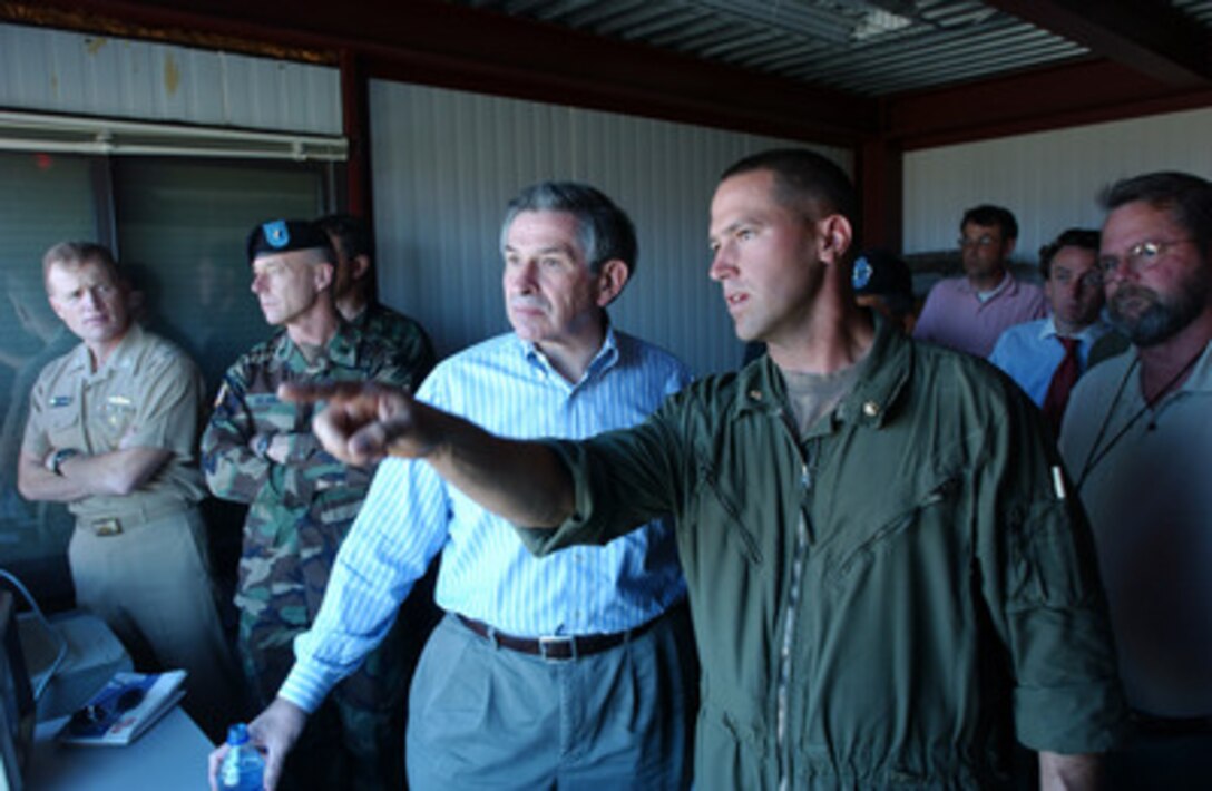 Deputy Secretary of Defense Paul Wolfowitz receives a tank qualifications briefing from Maj. Brian Kelly at Yakima Training Center in Yakima, Wash., on July 24, 2004. Deputy Secretary of Defense Paul Wolfowitz traveled to Yakima to observe military exercises. Kelly is a commander with the B Company, 4th Marine Tank Battalion. 