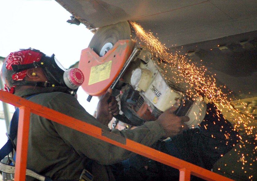 ROBINS AIR FORCE BASE, Ga. (AFPN) -- Senior Airman Aaron Cooper saws through the wing of a C-5A Galaxy as part of an engineering structural analysis project.  Airman Cooper is assigned to the base's 653rd Combat Logistics Support Squadron.  (U.S. Air Force photo by Sue Sapp)