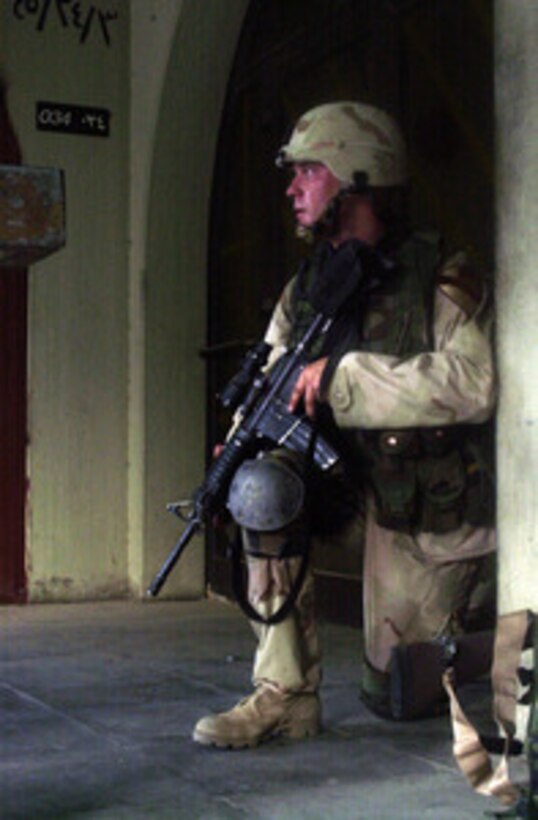 A soldier takes a defensive posture after being engaged by the enemy during a large-scale operation in the Sadamia area of Baghdad, Iraq, on July 22, 2004. Approximately 1,200 Iraqi Security Forces, 150 Iraqi National Guard and soldiers with the 1st Squadron, 9th Cavalry Regiment, 3rd Brigade, 1st Cavalry Division, conducted a large scale operation aimed at the criminal and terrorist stronghold around Talaa Square and Haifa Street. 