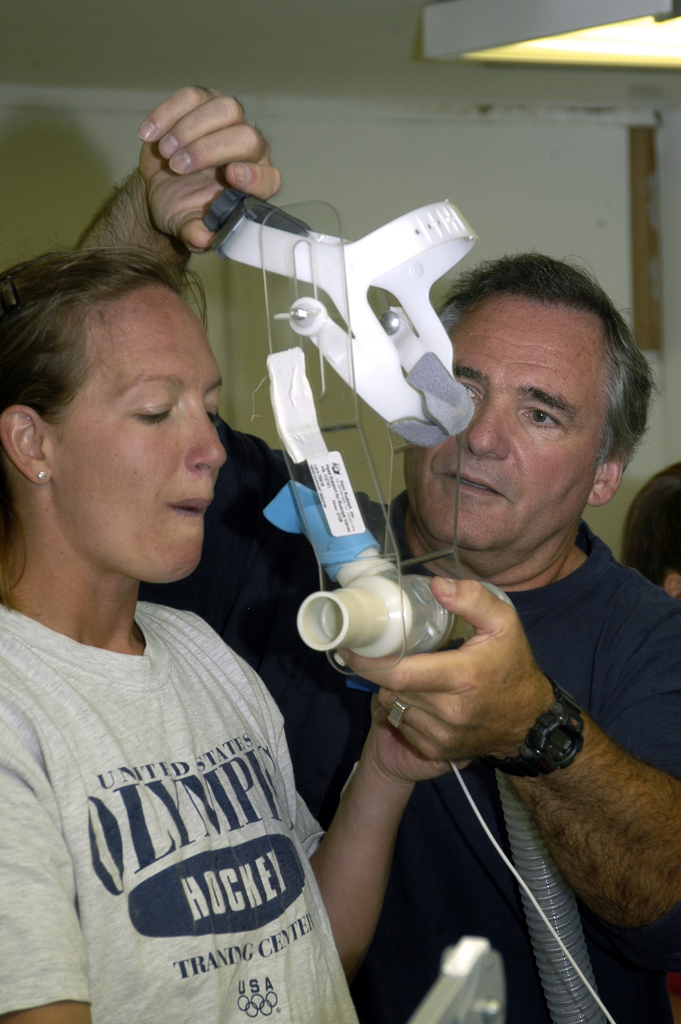 PIKES PEAK, Colo. - Dr. Ken Kambis (right) removes from the headgear from 1st Lt. Jacki Grant following her VO2 Max ride on the summit here.  Dr. Kambis is a scientist working on altitude research study.  Lieutenant Grant is one of 18 Airmen living on the summit of Pikes Peak this summer to gauge how the body reacts to living and exercising in a high-alpine environment.  (U.S. Air Force photo by 1st Lt. Greg Hignite)
