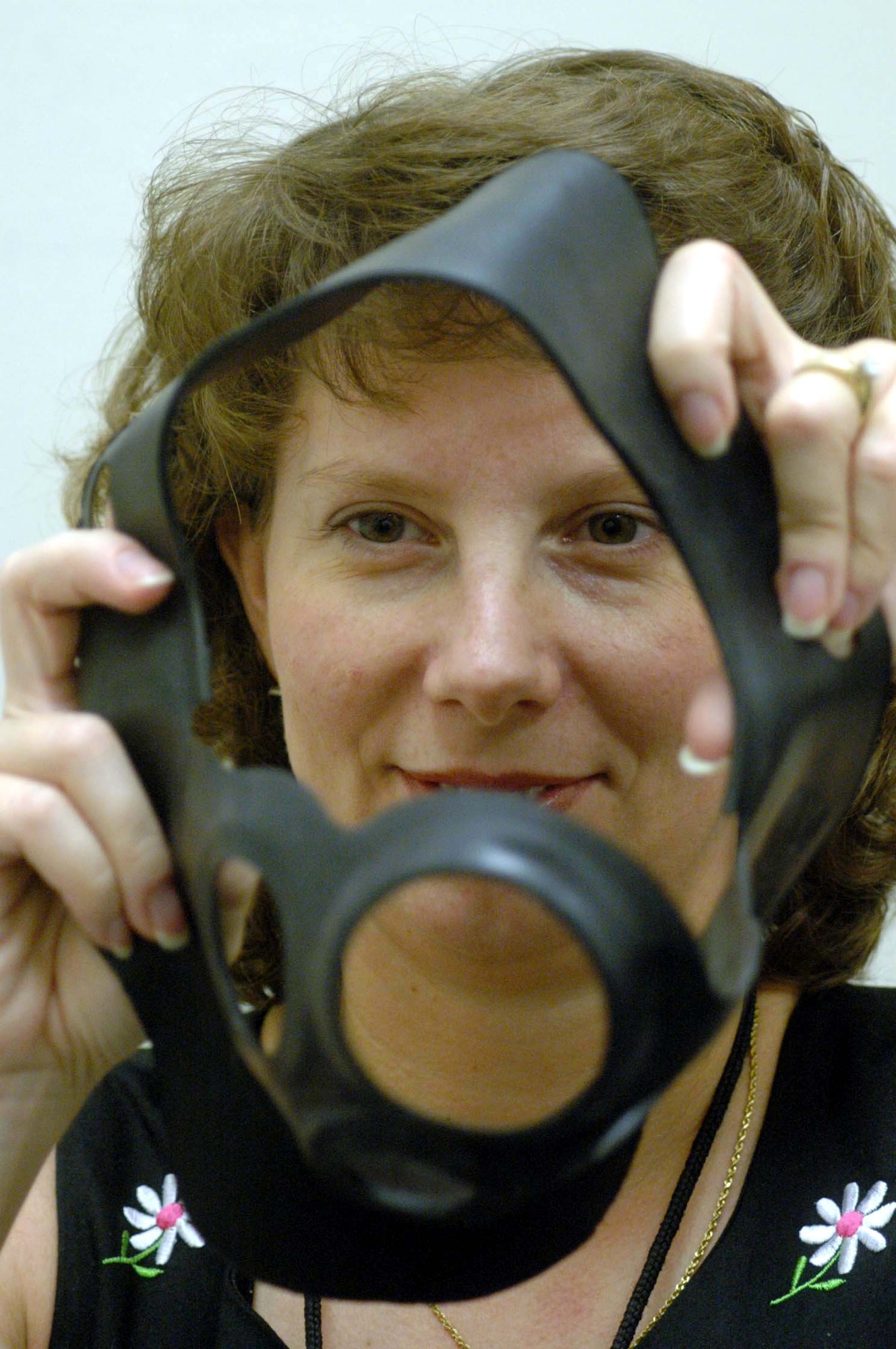 ROBINS AIR FORCE BASE, Ga. -- Laurie Beebe shows off the "second skin" liner that fits on the MCU-2P and the MCU-2A/P gas masks and adds an extra layer of protection against chemical, biological and nuclear warfare.  (U.S. Air Force photo by Sue Sapp)