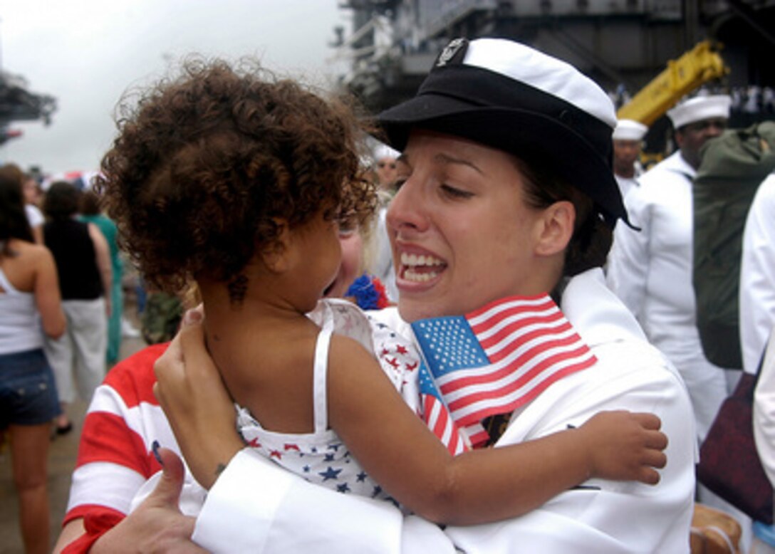 U.S. Navy Petty Officer 3rd class Leah Stiles embraces her daughter on the pier in Norfolk, Va., after returning from a six-month cruise on board the USS George Washington (CVN-73) on July 26, 2004. The aircraft carrier returned to its homeport of Norfolk after a deployment to the Mediterranean Sea and Persian Gulf in support of Operation Iraqi Freedom and Summer Pulse 2004. 