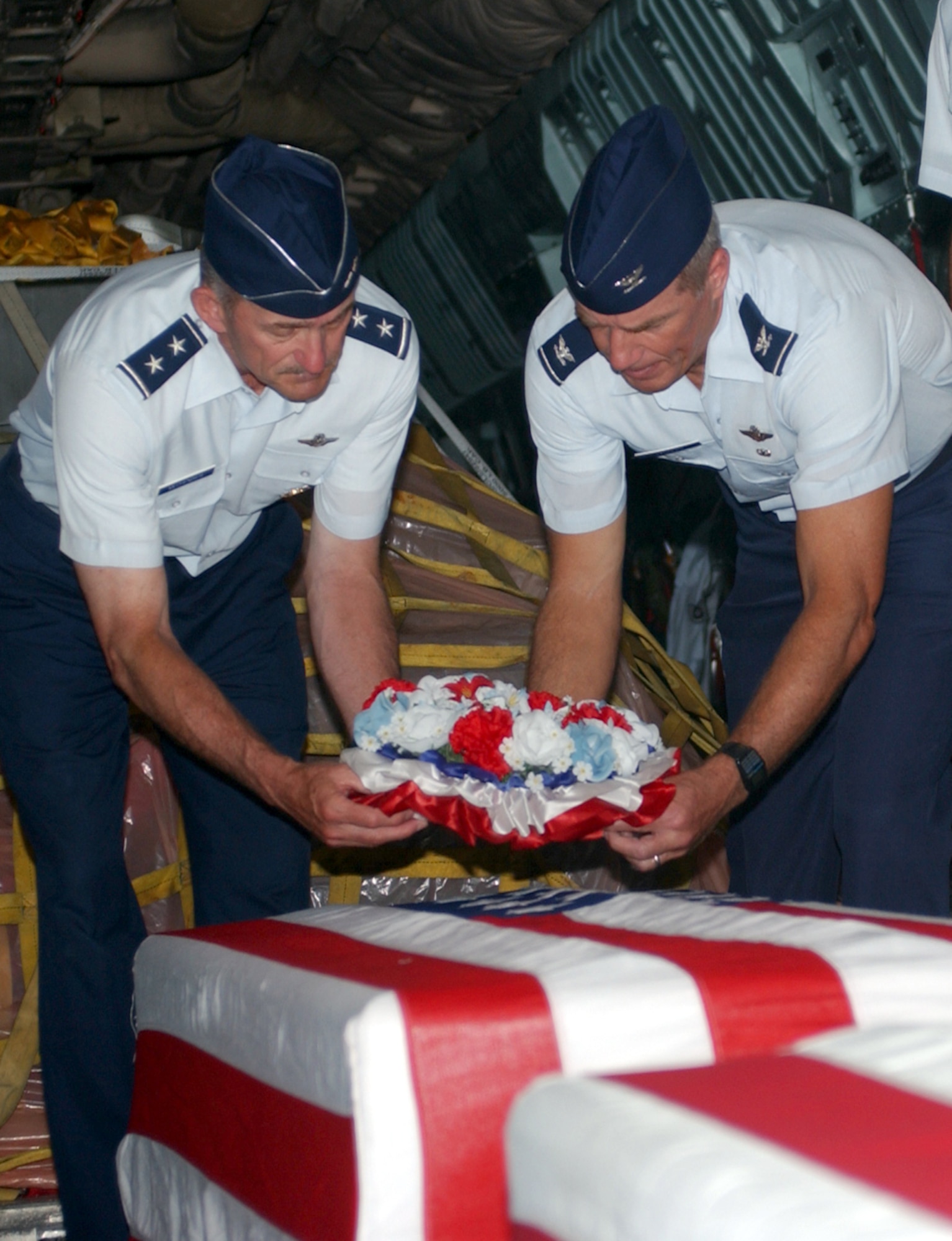 ANDERSEN AIR FORCE BASE, Guam -- Maj. Gen. Edward Mechenbier (left) and Col. Gregg Sanders lay a wreath on one of two transfer cases containing the remains of servicemembers from the Vietnam War during a repatriation ceremony here May 29.  General Mechenbier is the last Airman still serving who was a prisoner of war during Vietnam.  He flew the Hanoi Taxi on this mission to bring his fallen comrades home.  The Hanoi Taxi became the first C-141 Startlifter to repatriate American POWs from Vietnam on Feb. 12, 1973.  Colonel Sanders is the 13th Air Force vice commander.  (U.S. Air Force photo by Staff Sgt. Rasheen Douglas)