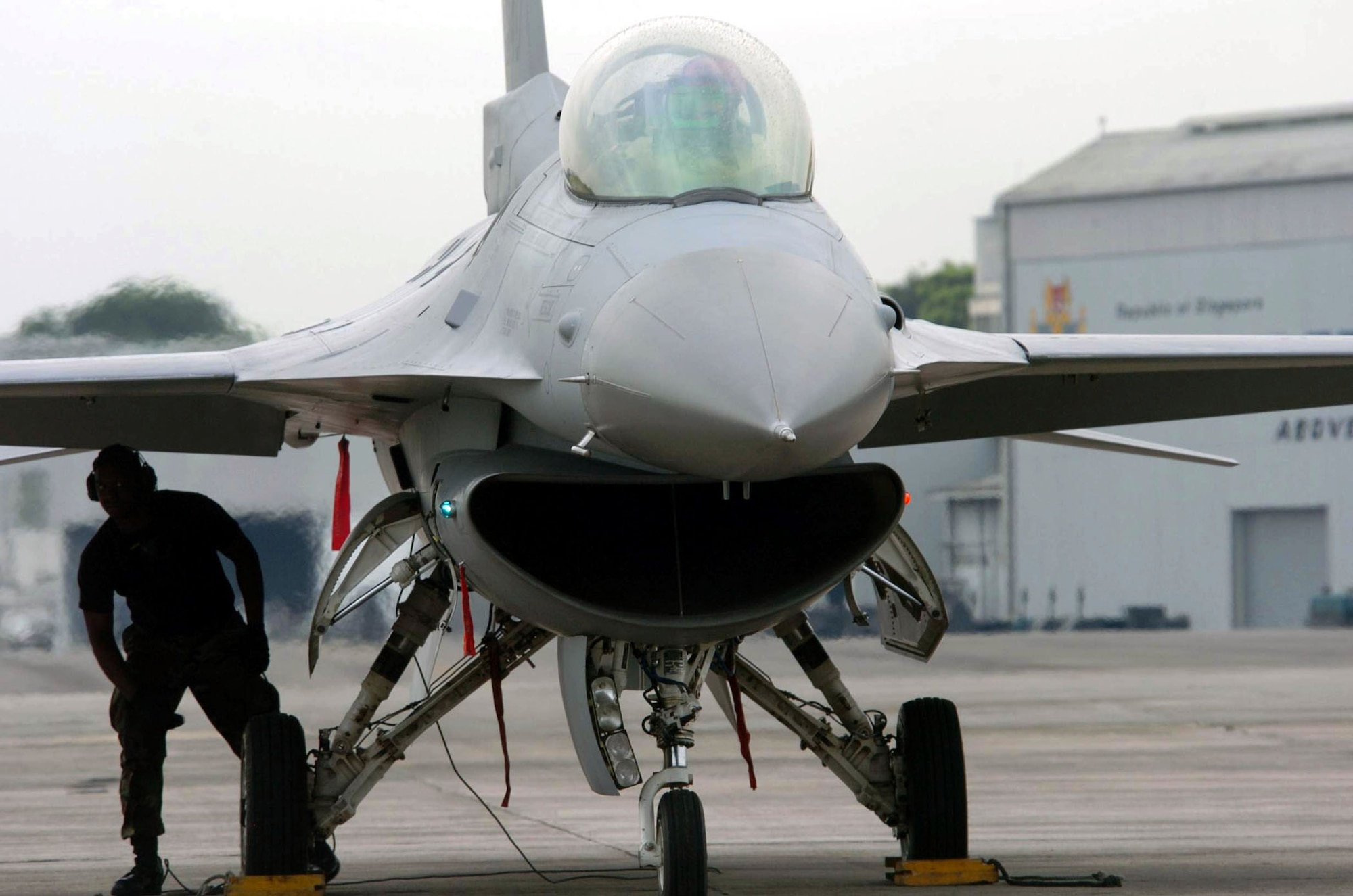 PAYA LEBAR AIR BASE, Singapore -- An F-16 Fighting Falcon crew chief from the 36th Fighter Squadron at Osan Air Base, South Korea, prepares to launch an aircraft here during Commando Sling 04-3.  U.S. and Singaporean Airmen trained together using realistic dissimilar aircraft air-to-air combat tactics.  (U.S. Air Force photo by Master Sgt. Val Gempis)