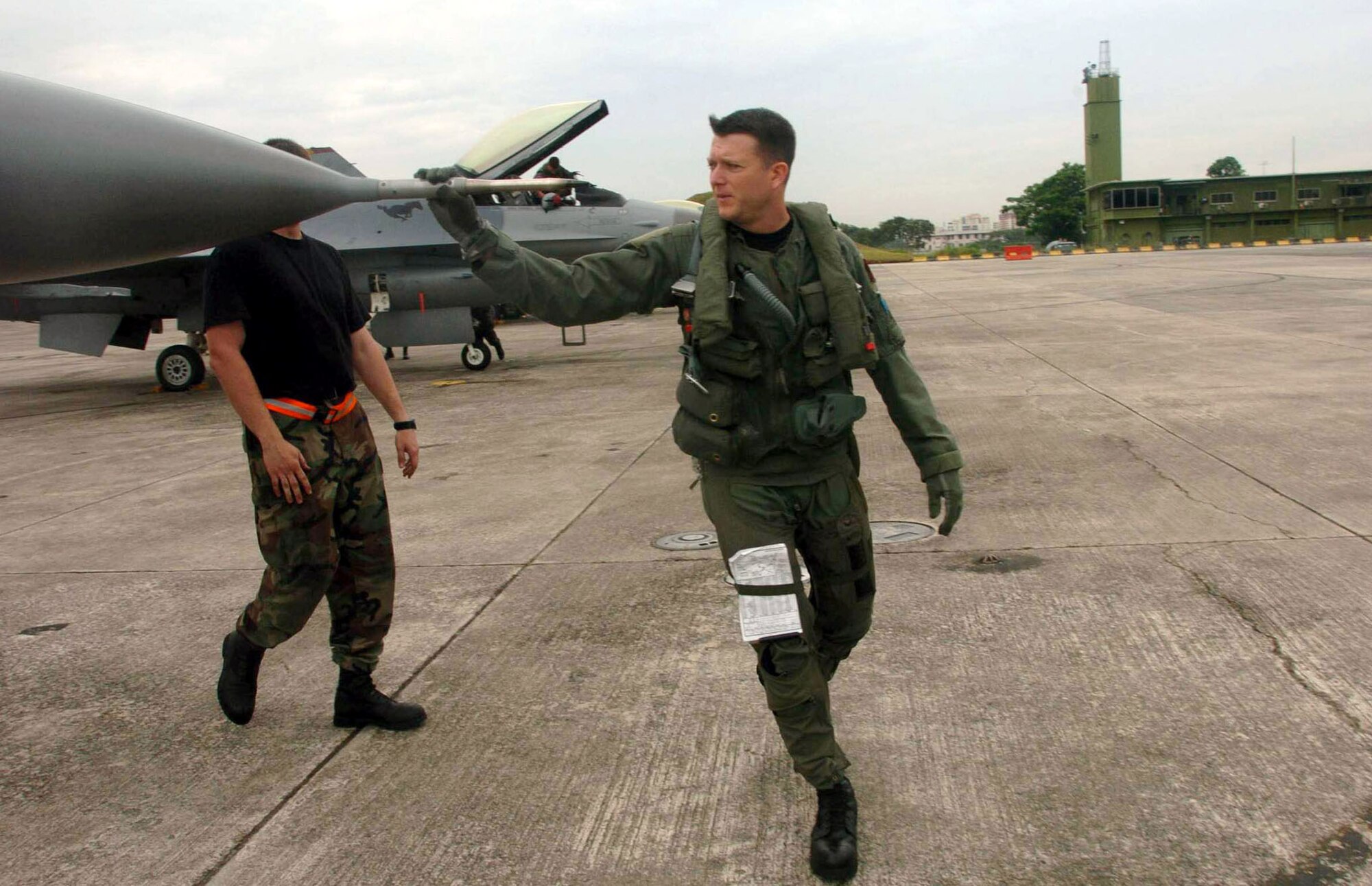 PAYA LEBAR AIR BASE, Singapore -- Maj. Mike Rose inspects his F-16 Fighting Falcon before a mission here during Commando Sling 04-3.  U.S. and Singaporean Airmen trained together using realistic dissimilar aircraft air-to-air combat tactics.  Major Rose is a pilot from the 36th Fighter Squadron at Osan Air Base, South Korea.  (U.S. Air Force photo by Master Sgt. Val Gempis)