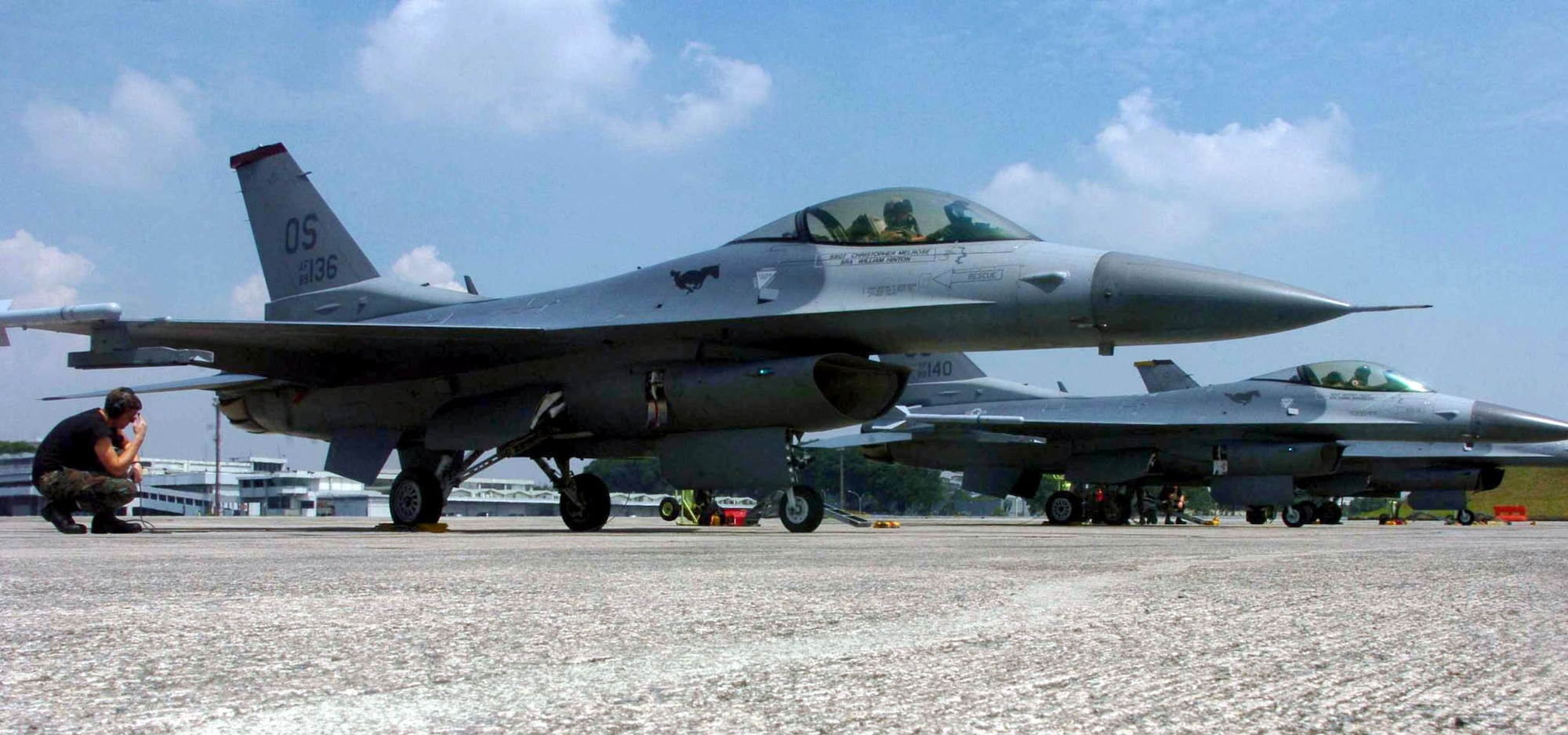 PAYA LABAR AIR BASE, Singapore -- F-16 Fighting Falcon crew chiefs from the 36th Maintenance Squadron at Osan Air Base, South Korea, prepare to launch jets during Commando Sling 04-3 here.  U.S. and Singaporean Airmen trained together using realistic dissimilar aircraft air-to-air combat tactics.  (U.S. Air Force photo by Master Sgt. Val Gempis)