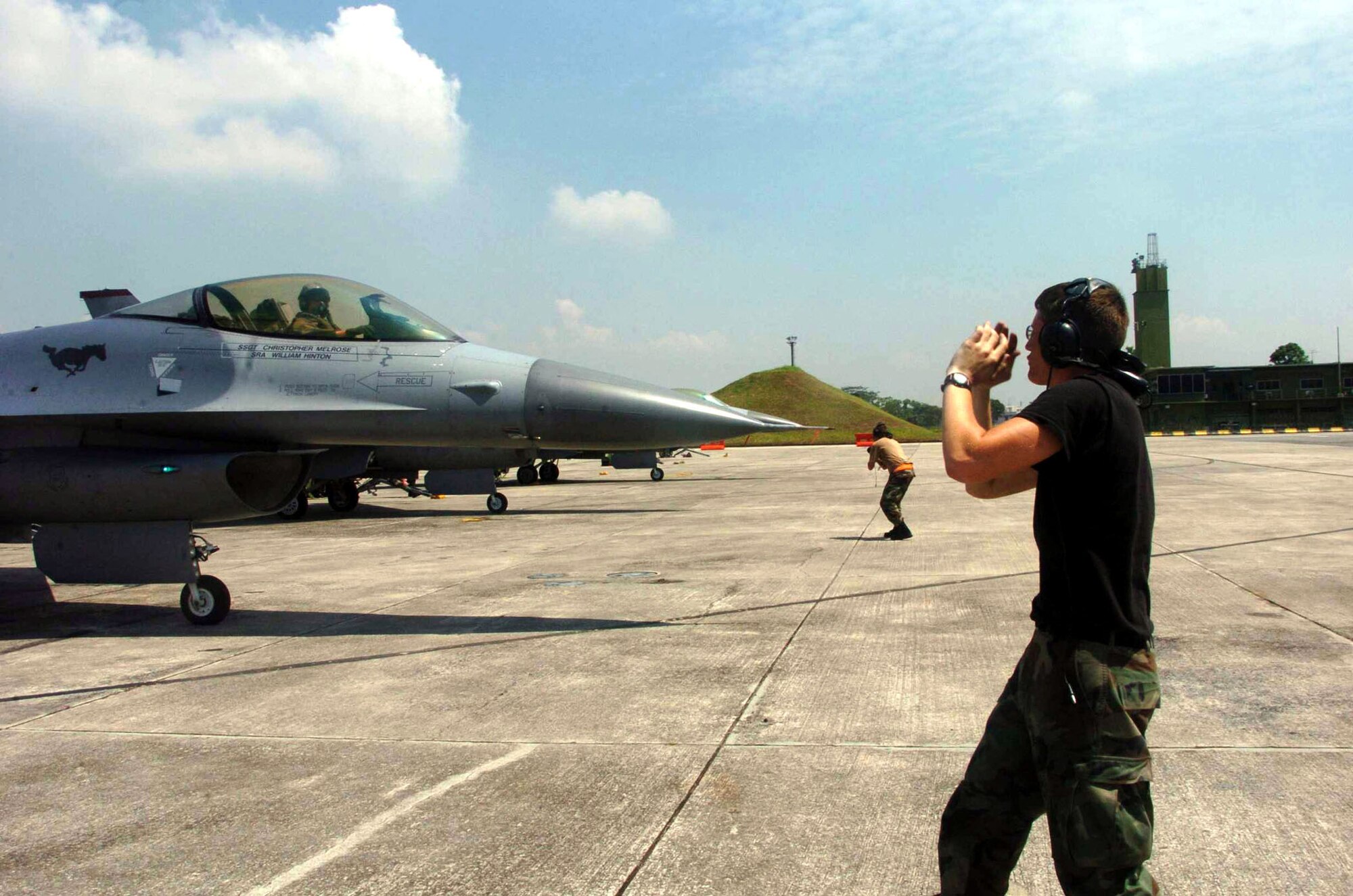 PAYA LABAR AIR BASE, Singapore -- Senior Airman Derek Griggs (foreground) and Staff Sgt. Jed Lawhun launch F-16 Fighting Falcons during Commando Sling 04-3 here.  U.S. and Singaporean Airmen trained together using realistic dissimilar aircraft air-to-air combat tactics.  Both Airmen are crew chiefs with the 36th Maintenance Squadron at Osan Air Base, South Korea.  (U.S. Air Force photo by Master Sgt. Val Gempis)