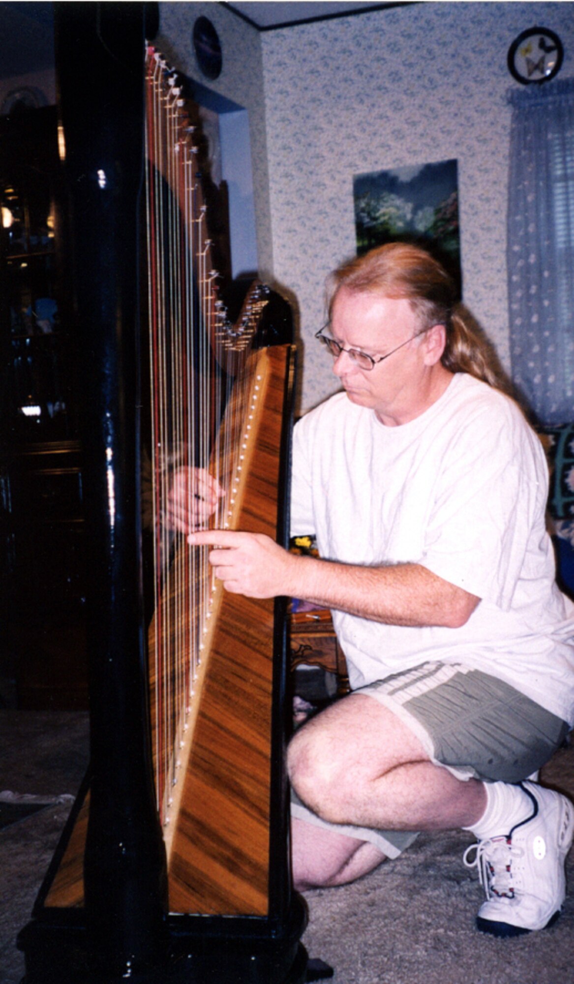 LONG BEACH, Miss. -- Fred McMichael plays the harp that took him three years to make at his home here.  He is a local network administrator at nearby Keesler Air Force Base.  (U.S. Air Force photo by Susan Griggs)