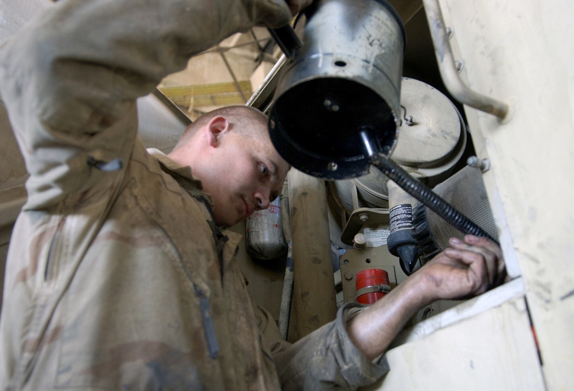 BAGRAM AIR BASE, Afghanistan -- Staff Sgt. Christopher Logan tops off oil in a forklift here after he replaced its engine.  He is assigned to the 455th Expeditionary Logistics Readiness Squadron and is deployed from Davis-Monthan Air Force Base, Ariz.  (U.S. Air Force photo by Master Sgt. Andrew Gates)