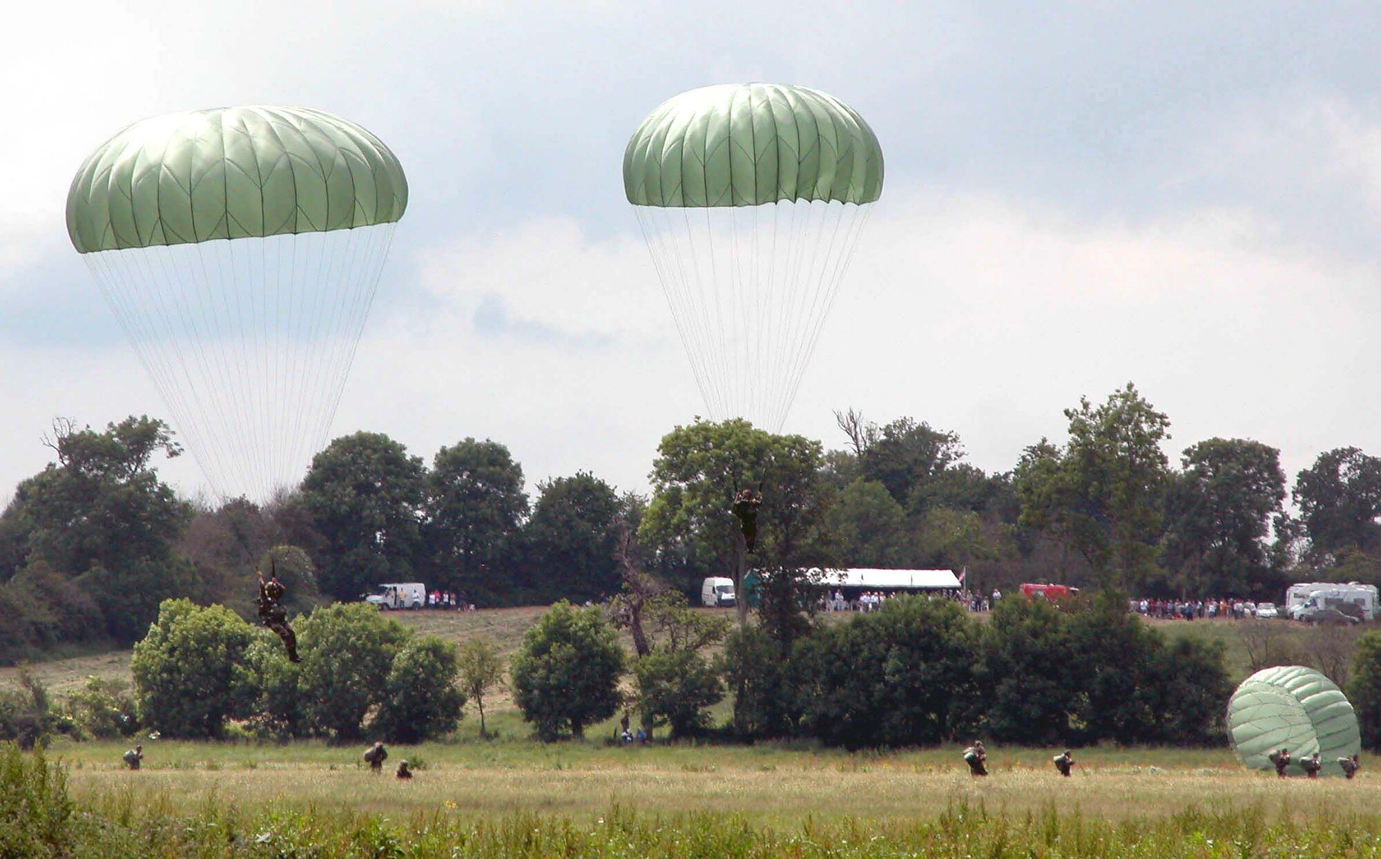 SAINTE-MERE-EGLISE, France -- Paratroopers land in a drop zone near here June 5 during a tribute to airborne Soldiers who died in the liberation of France in 1944.  (Department of Defense photo by Jim Garamone)