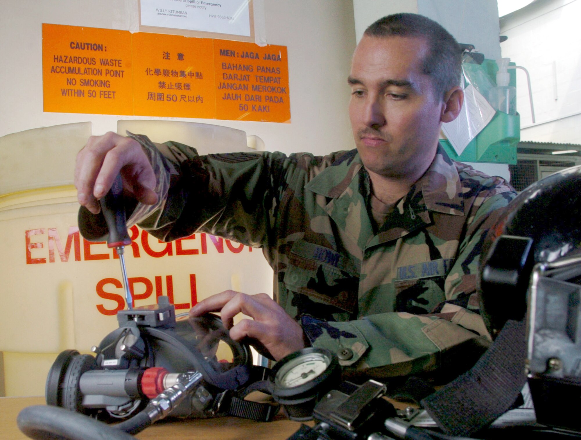 PAYA LEBAR AIR BASE, Singapore -- Tech. Sgt. Randy Howe uses a screwdriver to inspect a self-contained breathing apparatus during routine maintenance here.  Sergeant Howe is a fuels specialist from the 497th Combat Training Squadron.  The squadron supports regular temporary-duty rotations of U.S. fighter aircraft.  (U.S. Air Force photo by Master Sgt. Val Gempis)