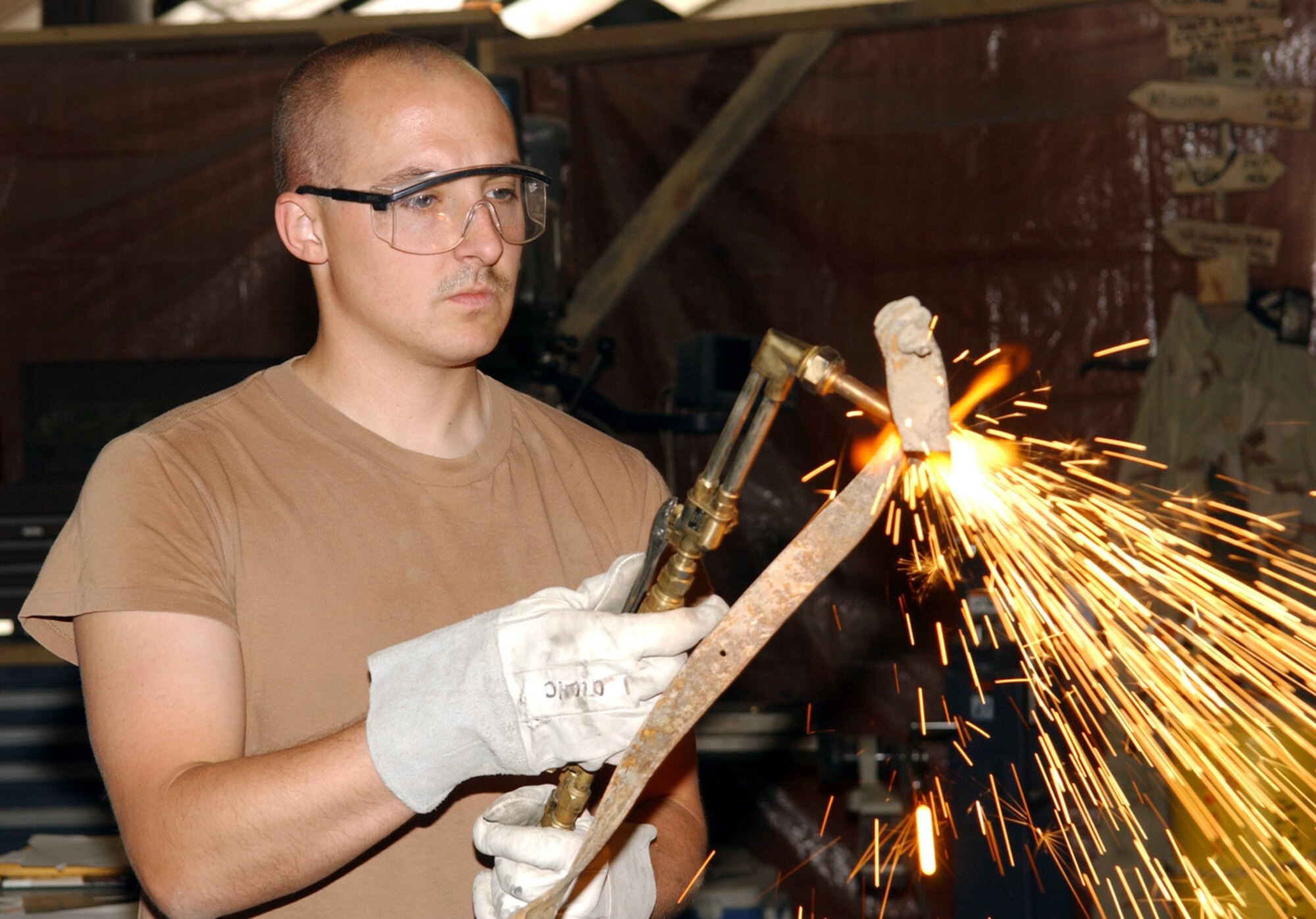 BAGRAM AIR BASE, Afghanistan -- Senior Airman Brian Wakelee uses a torch to cut brackets from metal salvaged during the repair of an Army nitrogen cart.  He is assigned to the 455th Expeditionary Aircraft Maintenance Squadron's fabrication branch here.  (U.S. Air Force photo by Master Sgt. Andrew Gates)