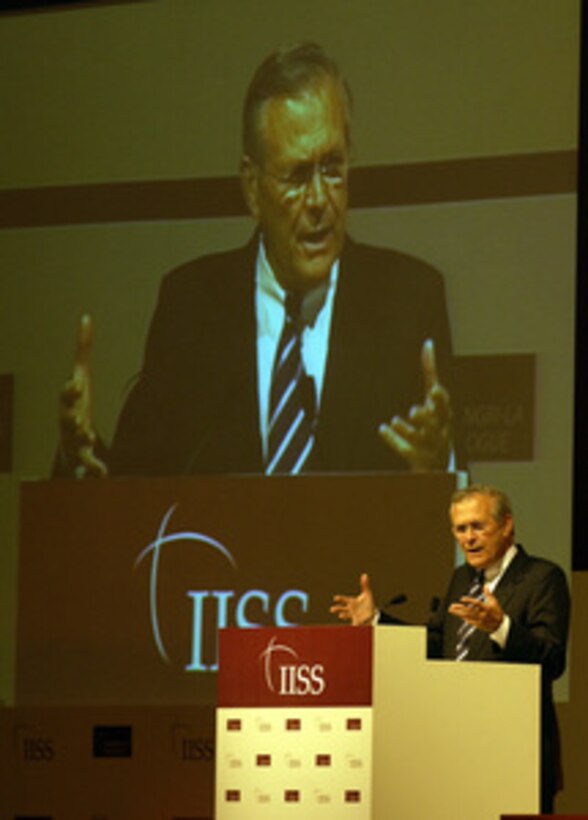 Secretary of Defense Donald H. Rumsfeld is dwarfed by a video image of himself as he addresses the delegates of the 3rd International Institute of Strategic Studies Asia Security Conference held in Singapore on June 5, 2004. Rumsfeld is in Singapore to talk to sailors and Marines aboard the USS Essex (LHD 2) and to attend the conference. 
