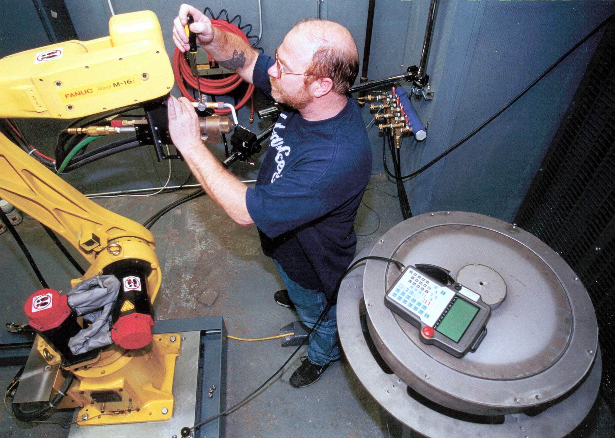 TINKER AIR FORCE BASE, Okla. -- James Genzler adjusts a thermal spray gun that is used to coat aircraft engine parts here with tungsten carbide and cobalt.  The powdered mixture is being tested to replace cancer-causing chrome.  (U.S. Air Force photo by Eddie Edge)