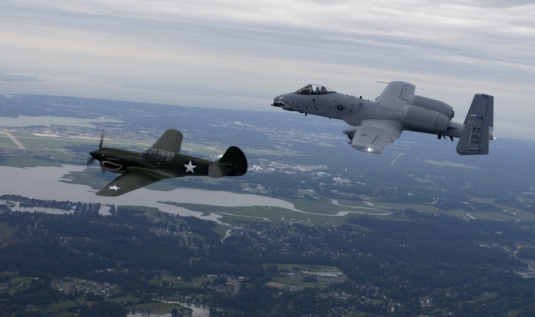 OVER LANGLEY AIR FORCE BASE, Va. -- A P-40 Tomahawk and an A-10 Thunderbolt II fly in close formation here June 4. This formation represents the heritage between the 23rd Fighter Group of World War II which stood down to become the famous Flying Tigers, and the legacy which continues today. The P-40 was brought to Langley for the Flying Tigers reunion. (U.S. Air Force photo by Tech. Sgt. Ben Bloker)