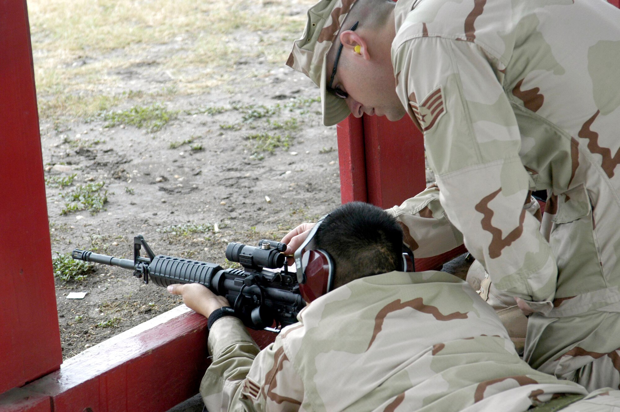LACKLAND AIR FORCE BASE, Texas -- Staff Sgt. Scott Grant (right) teaches Senior Airman Jeffery Salonga to use an M-4 carbine during a Basic Combat Convoy Course here.  Sergeant Grant was helping students sight in the "red dot" aiming optics of their new rifles.  He is a course instructor and is assigned to the 342nd Training Squadron.  (U.S. Air Force photo by James Coburn)