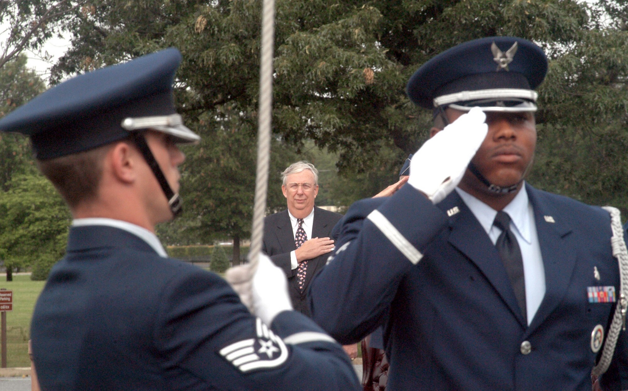 ANDREWS AIR FORCE BASE, Md. -- Secretary of the Air Force Dr. James G. Roche places his hand over his heart as members of the 89th Airlift Wing base honor guard raise the flag during the playing of the National Anthem during a Flag Day ceremony here June 14.  (U.S. Air Force photo by Bobby Jones)
