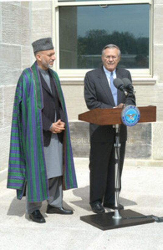Secretary of Defense Donald H. Rumsfeld (right) talks to reporters during a media availability with Afghan President Hamid Karzai (left) following their meeting in the Pentagon on June 14, 2004. 