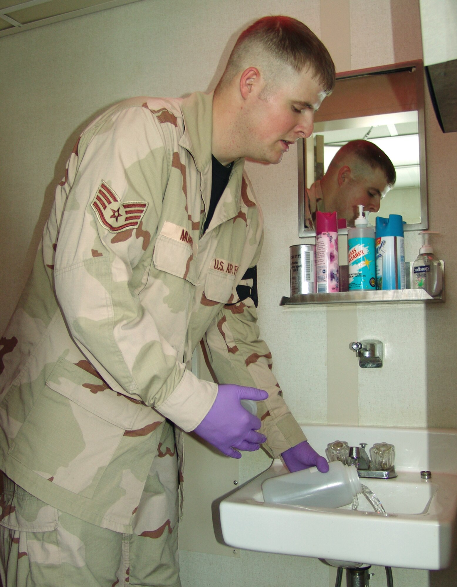 SOUTHWEST ASIA -- Staff Sgt. Justin Murphy pours out a water sample at a latrine aboard an Army ship.  The Airmen who make up the 2nd Preventive Medicine Team Air Force are responsible for the healthy living environment of 60,000 Soldiers at eight different camps.  (U.S. Air Force photo by Staff Sgt. Martin Jackson)