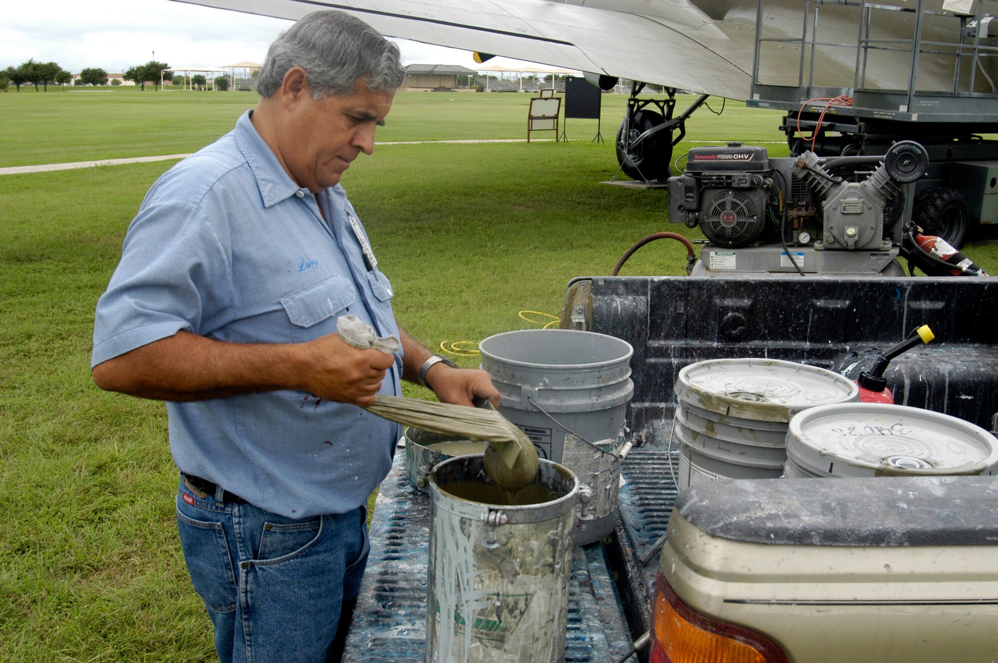 LACKLAND AIR FORCE BASE, Texas -- Larry Sterling strains the paint for a World War II vintage C-47 Skytrain.  He is a contracted painter who restores planes around the base.  (U.S. Air Force photo by James Coburn)