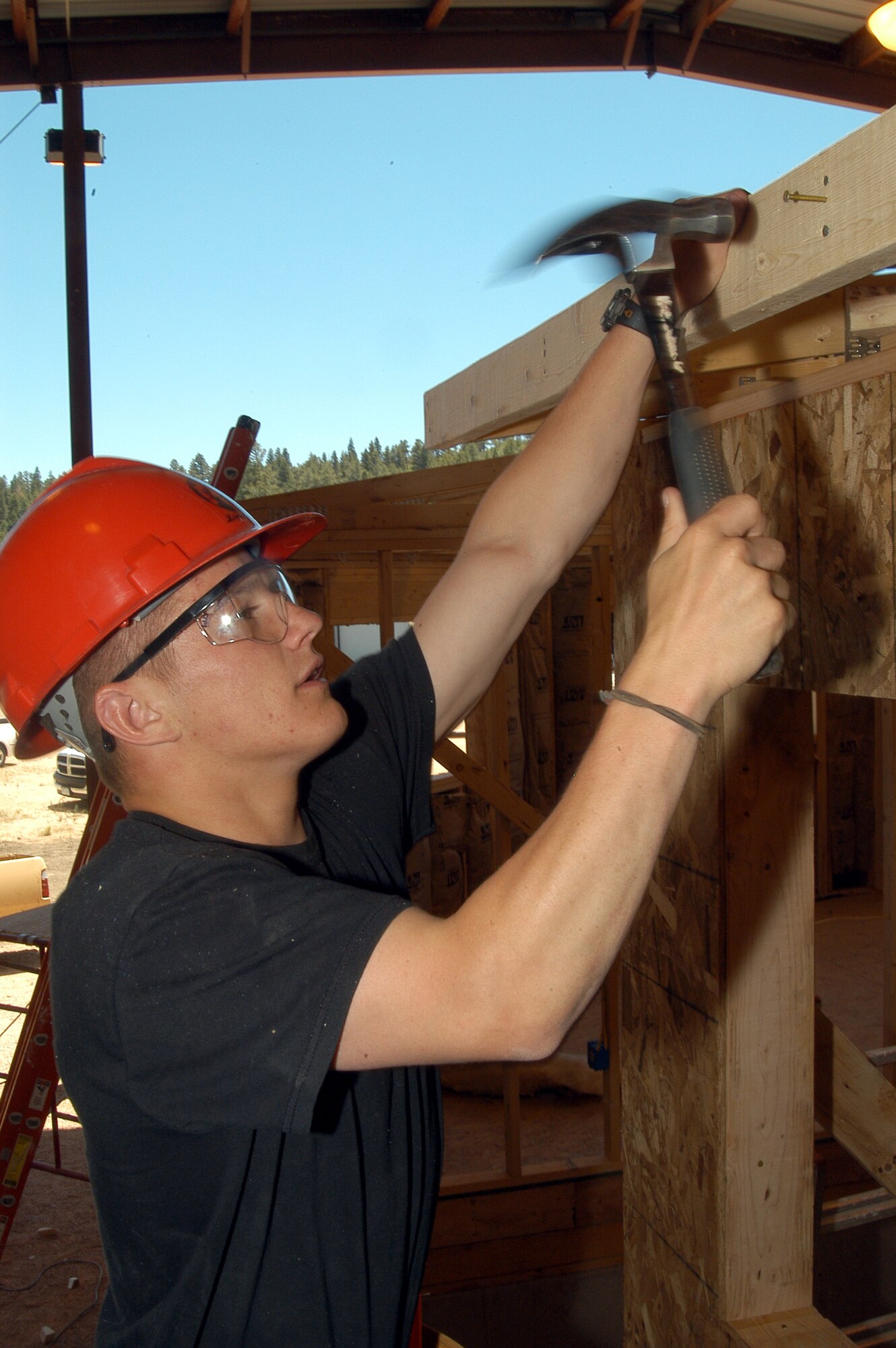 U.S. AIR FORCE ACADEMY, Colo. -- Cadet 2nd class Chad Winters hammers a board into the frame of a hogan, a traditional Navajo home.  Each summer, cadets in the field engineering readiness laboratory here build the shelters to learn civil engineering from Air Force craftsmen.  Once the homes are completed, they are donated to Southwestern Navajo tribes.  (U.S. Air Force photo by Tech. Sgt. James A. Rush)