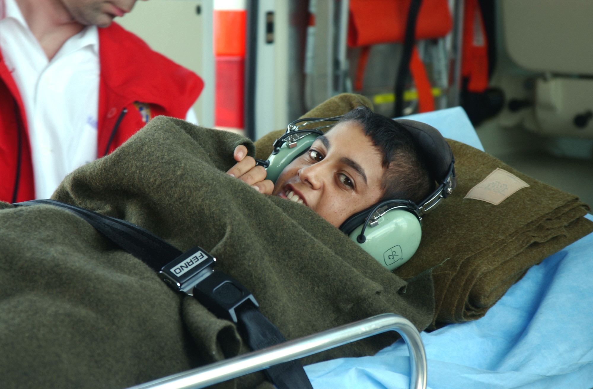 BUDAPEST, Hungary -- Abbas Jabbar, a 13-year-old Iraqi, gives a smile as he is moved into a Hungarian ambulance at the international airport here.  A dozen crewmembers aboard a C-17 Globemaster III helped move him to Hungary after he was injured last month when he ran in front of a Hungarian convoy patrolling near Baghdad, Iraq.  (U.S. Air Force photo by Staff Sgt. Jason Lake)