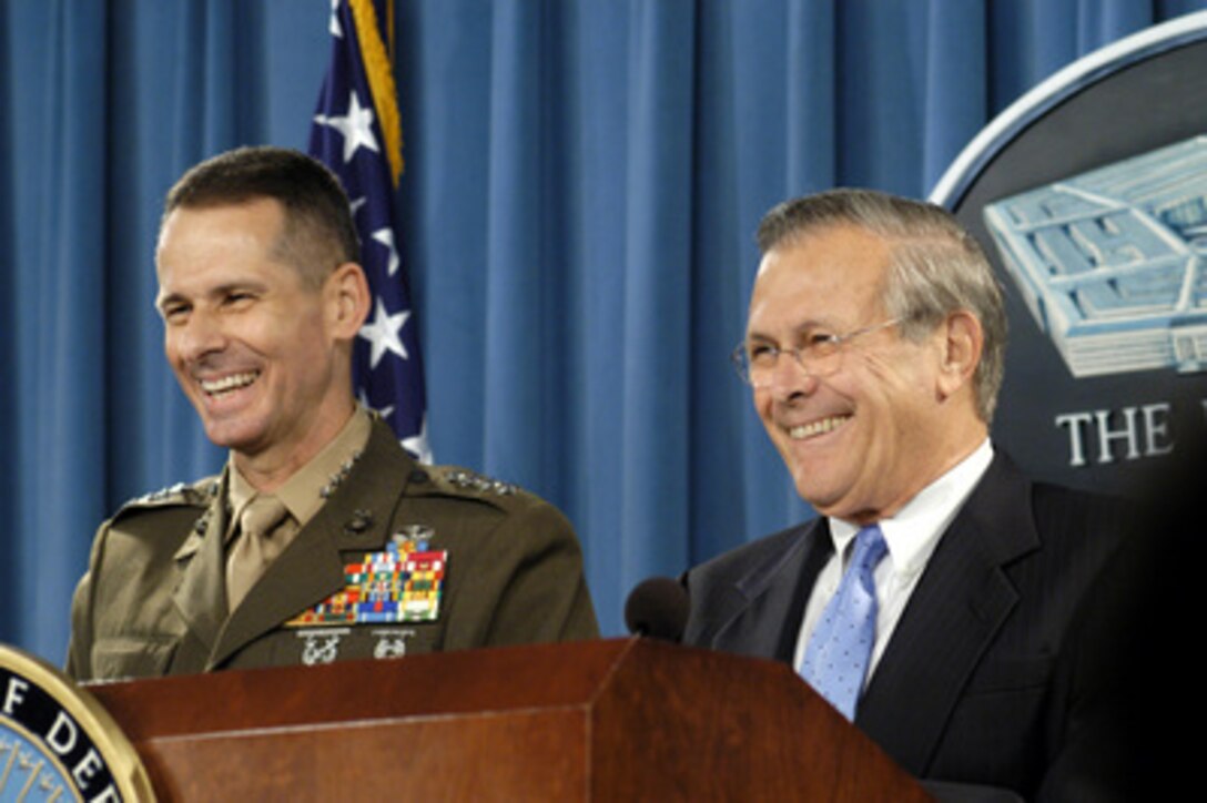 Secretary of Defense Donald H. Rumsfeld (right) and Vice Chairman of the Joint Chiefs of Staff Gen. Peter Pace, U.S. Marine Corps, smile at a reporter's question during a Pentagon press briefing on June 17, 2004. Rumsfeld and Pace updated reporters on Iraq and took questions. 