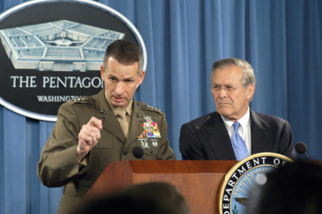 Vice Chairman of the Joint Chiefs of Staff Gen. Peter Pace, U.S. Marine Corps, responds to a reporter's question concerning military operations in the Iraqi city of Fallujah during a June 17, 2004, Pentagon press briefing. Pace and Secretary of Defense Donald H. Rumsfeld (right) updated reporters on Iraq and took questions. 