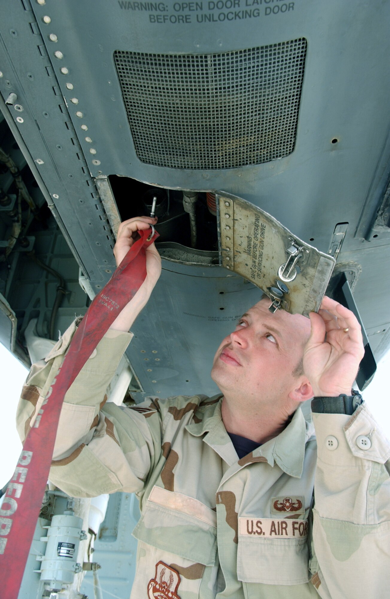 BAGRAM AIR BASE, Afghanistan -- Staff Sgt. Thomas places a safety pin on the 30 mm gun of an A-10 Thunderbolt II during an in-flight emergency exercise.  Sergeant Thomas is an explosive ordnance disposal technician with the 455th Expeditionary Civil Engineer Flight here.  (Digitally altered U.S. Air Force photo by Master Sgt. Andrew Gates)